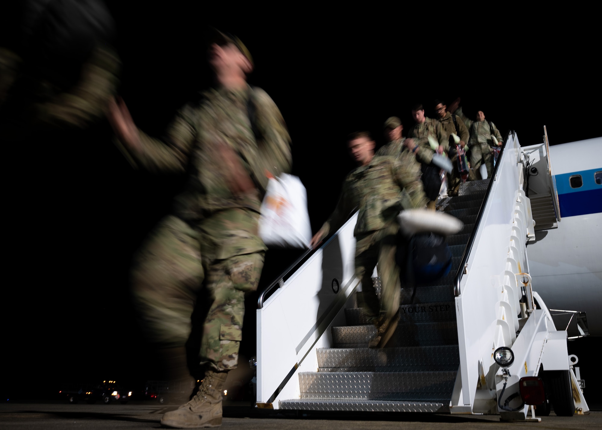 Airmen exit a commercial aircraft upon returning to Shaw Air Force Base.