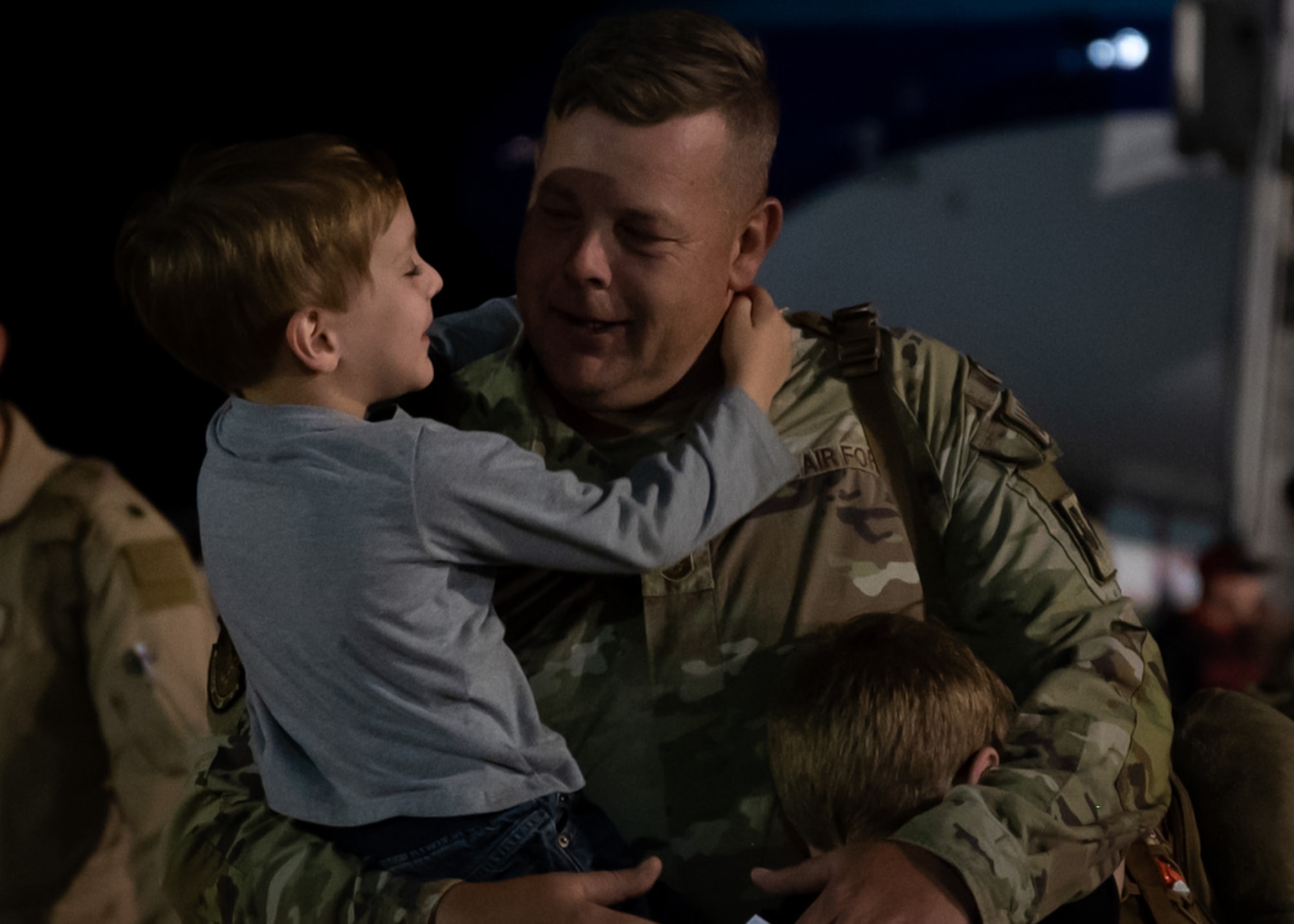 An Airman hugs his children after returning to Shaw Air Force Base
