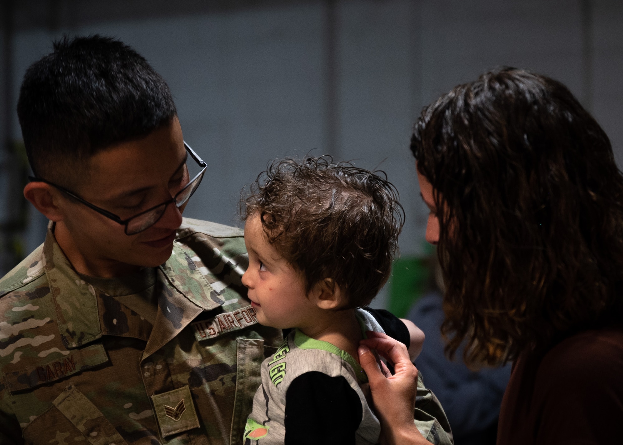 Airman hugs child and wife after returning to Shaw Air Force Base.