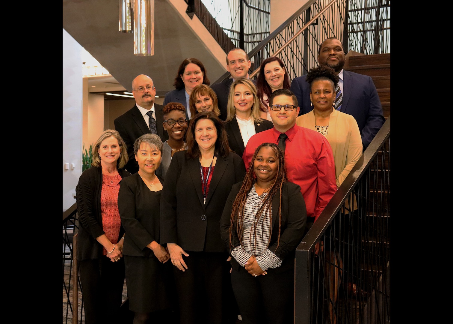 Group of professionals standing together on the stairs.