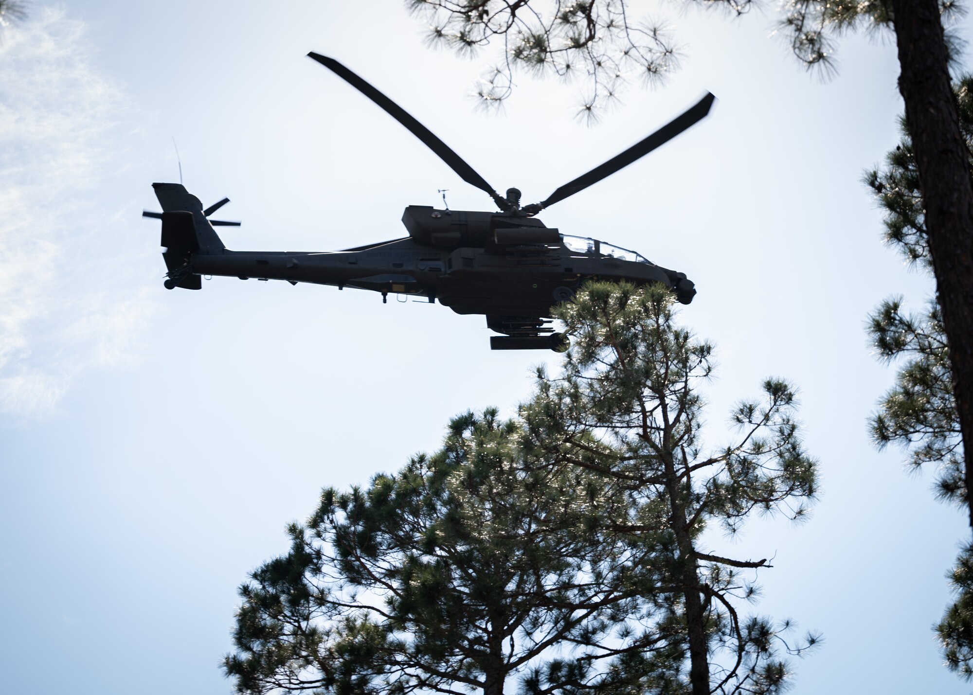 An Army AH-64 Apache helicopter flies over Camden Battlefield during reinterment ceremony for fallen Revolutionary War soldiers.