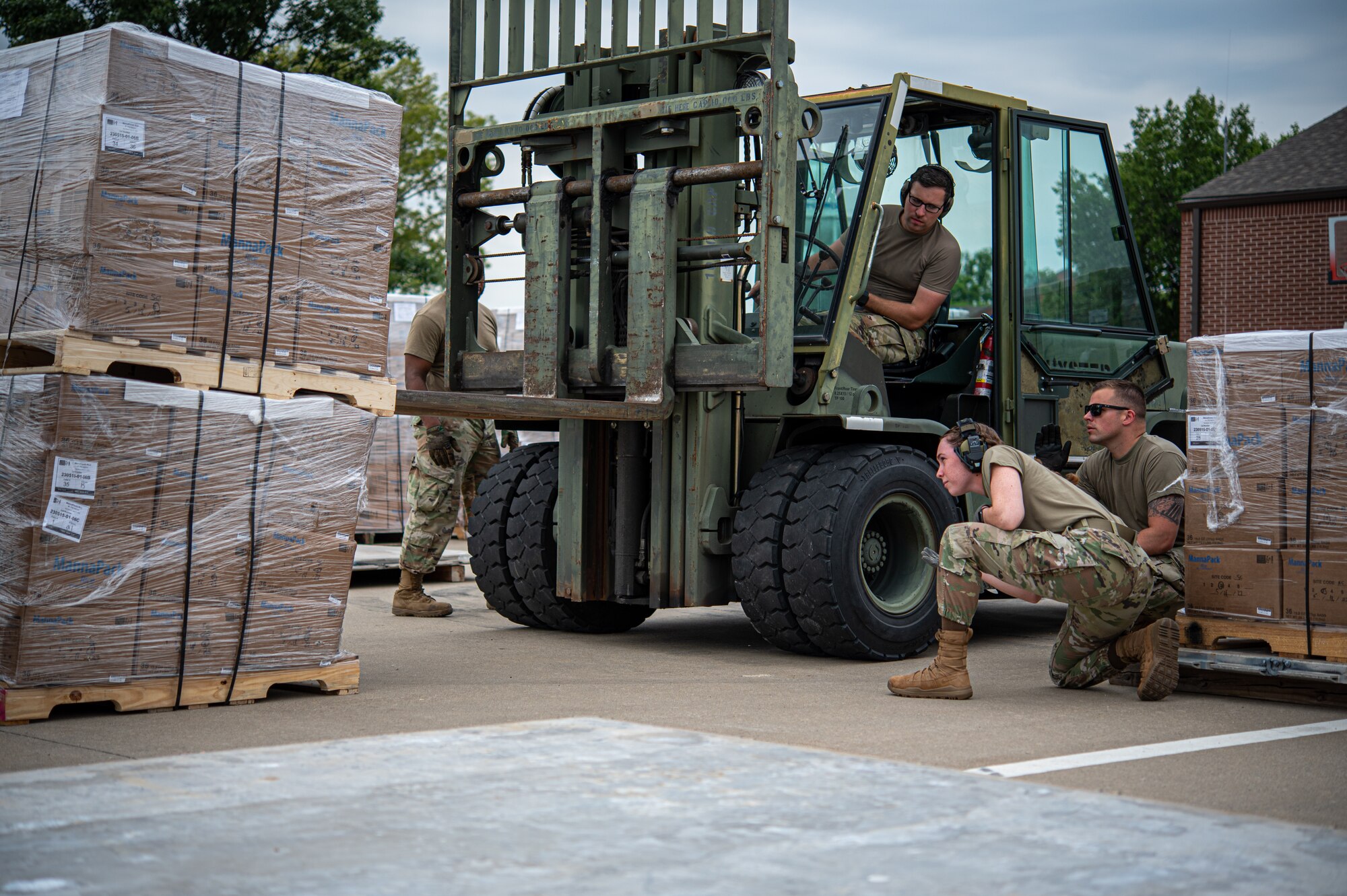 Airman uses forklift to carry pallet.
