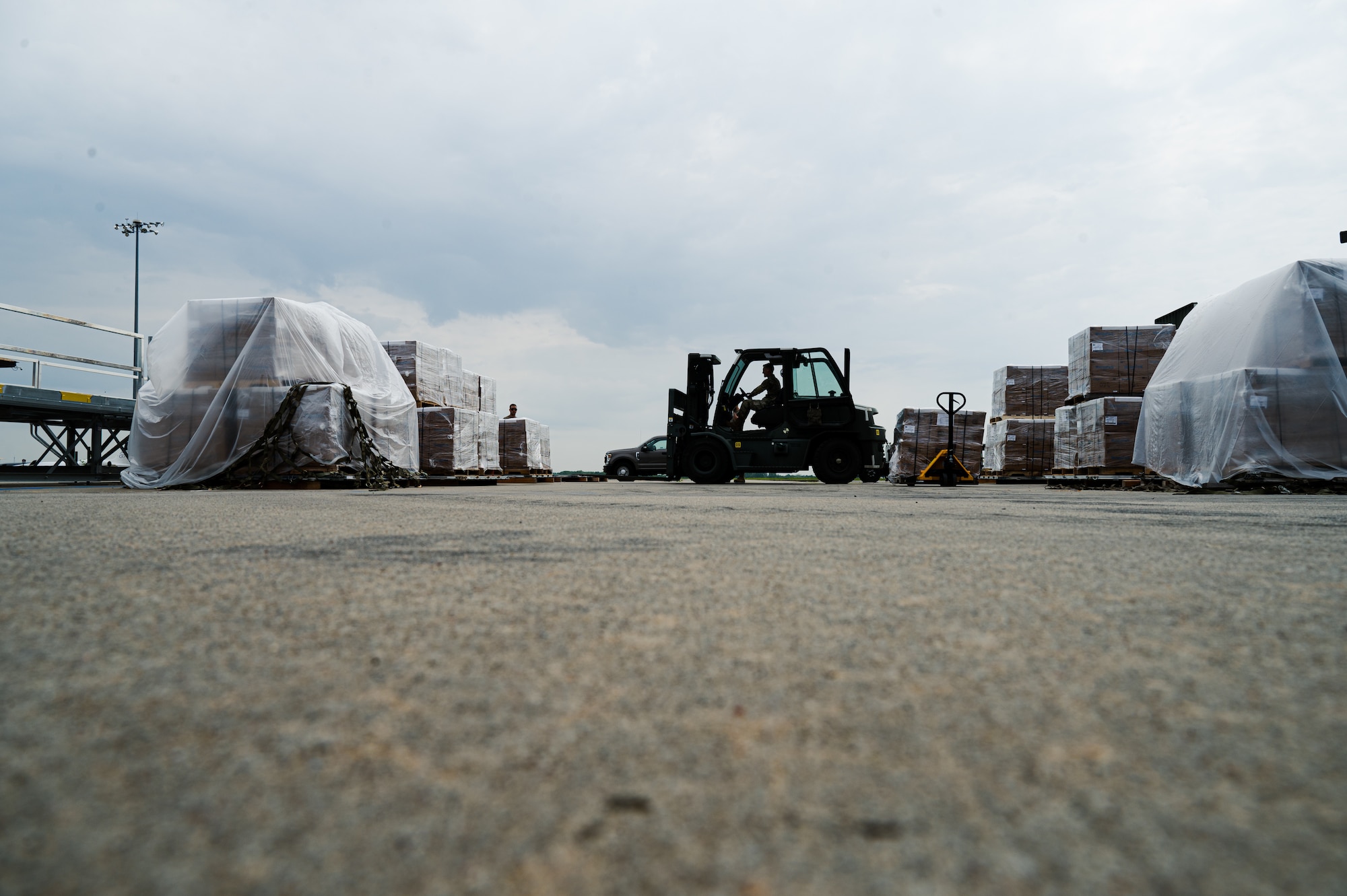 Airman uses forklift to carry pallet.