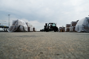 Airman uses forklift to carry pallet.