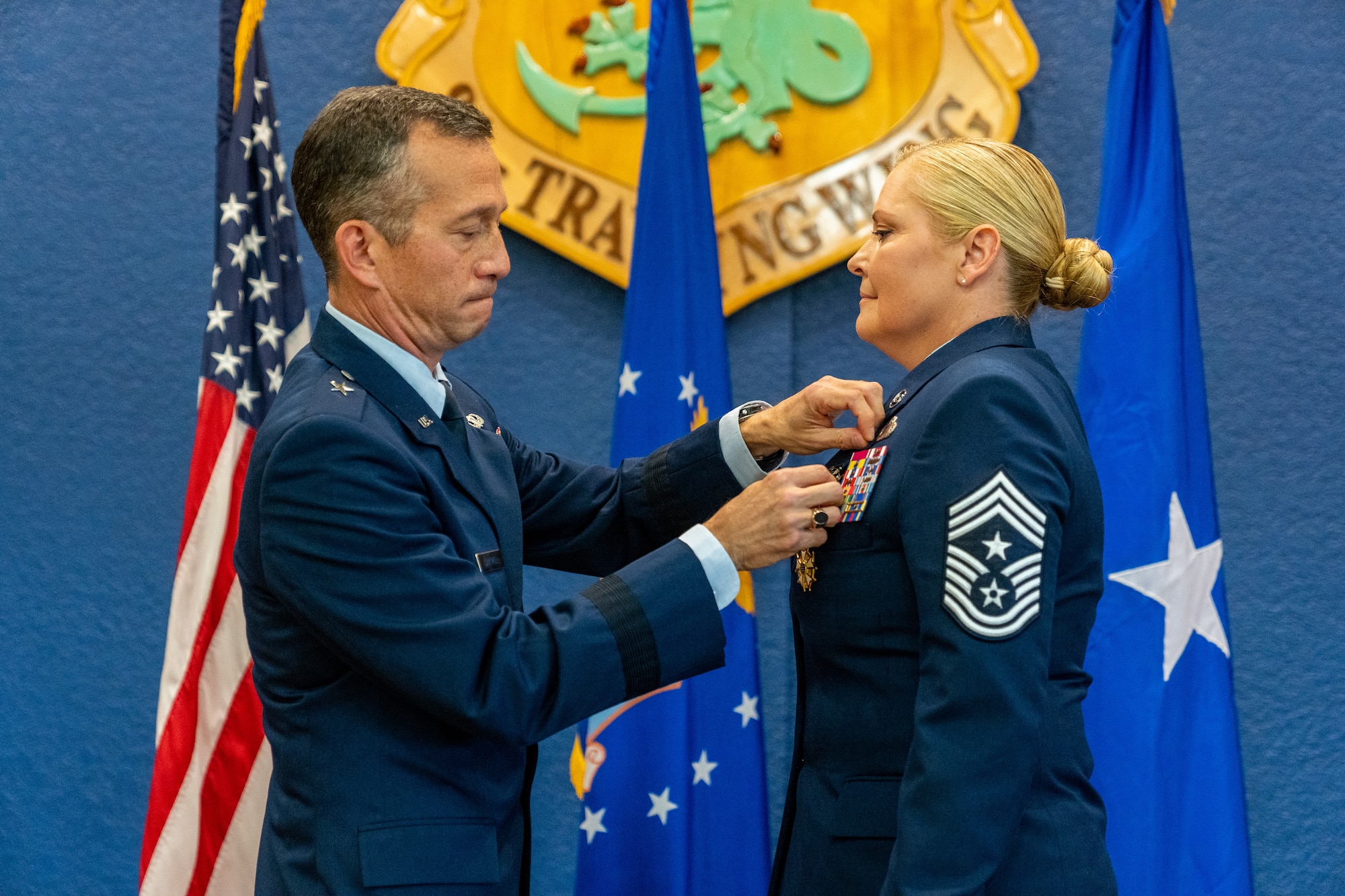 U.S. Air Force Brig. Gen. Houston Cantwell, Jeanne M. Holm Center for Oﬃcer Accessions and Citizen Development commander, pins the Legion of Merit medal onto Chief Master Sgt. Sarah Esparza, 81st Training Wing command chief master sergeant, during her retirement ceremony at Keesler Air Force Base, Mississippi, June 1, 2023.