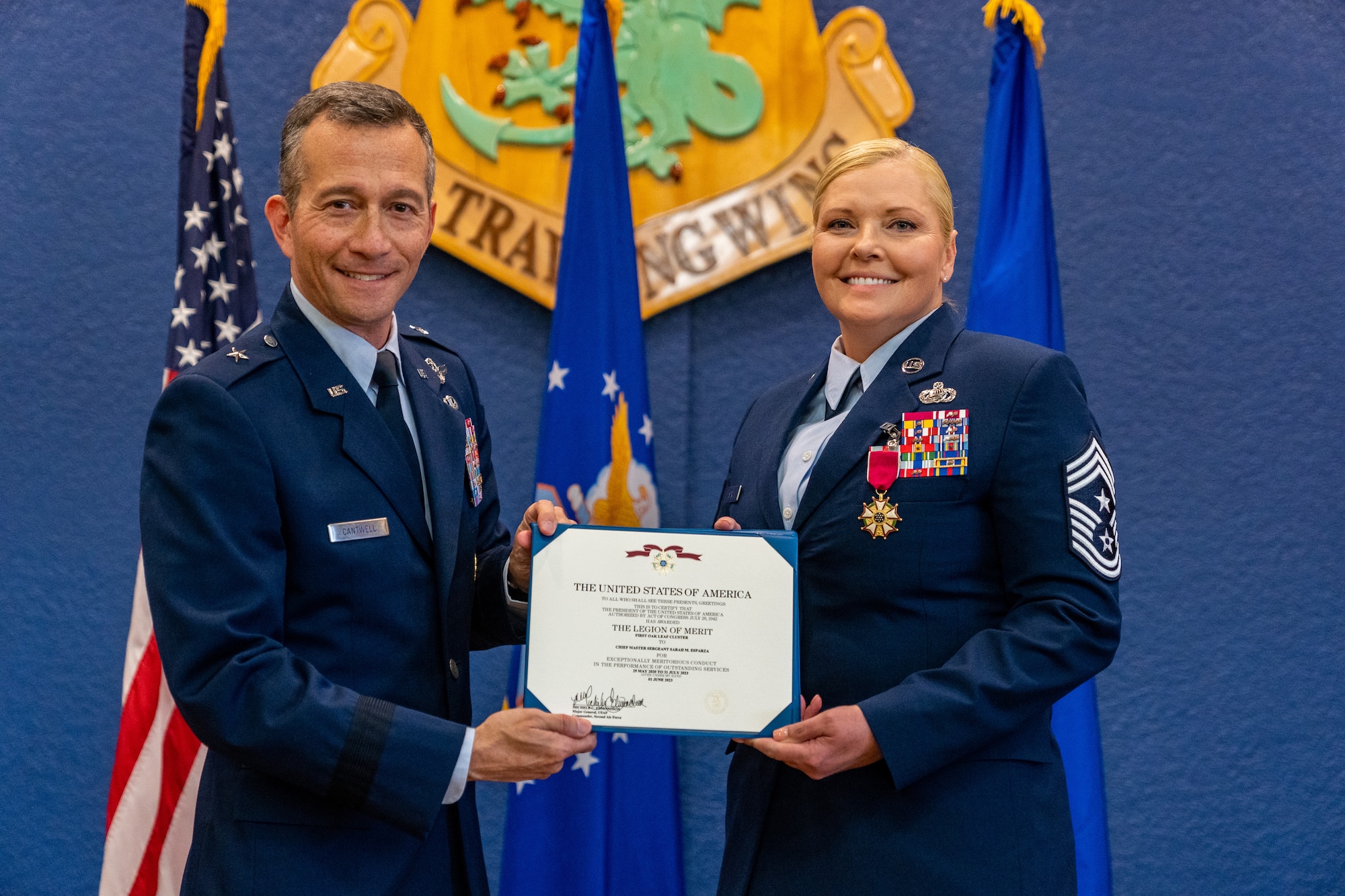 U.S. Air Force Brig. Gen. Houston Cantwell, Jeanne M. Holm Center for Oﬃcer Accessions and Citizen Development commander, and Chief Master Sgt. Sarah Esparza, 81st Training Wing command chief master sergeant, pose with her Legion of Merit certificate during her retirement ceremony at Keesler Air Force Base, Mississippi, June 1, 2023.