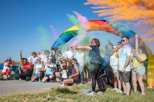 Airmen and families take a group photo after the Pride Month color run at Altus Air Force Base, Oklahoma, June 24, 2022. According to a Rand survey, 6.1 percent of people in the U.S. military self-identified as part of the LGBTQ+ community. (U.S. Air Force photo by Staff Sgt. Breanna Klemm)