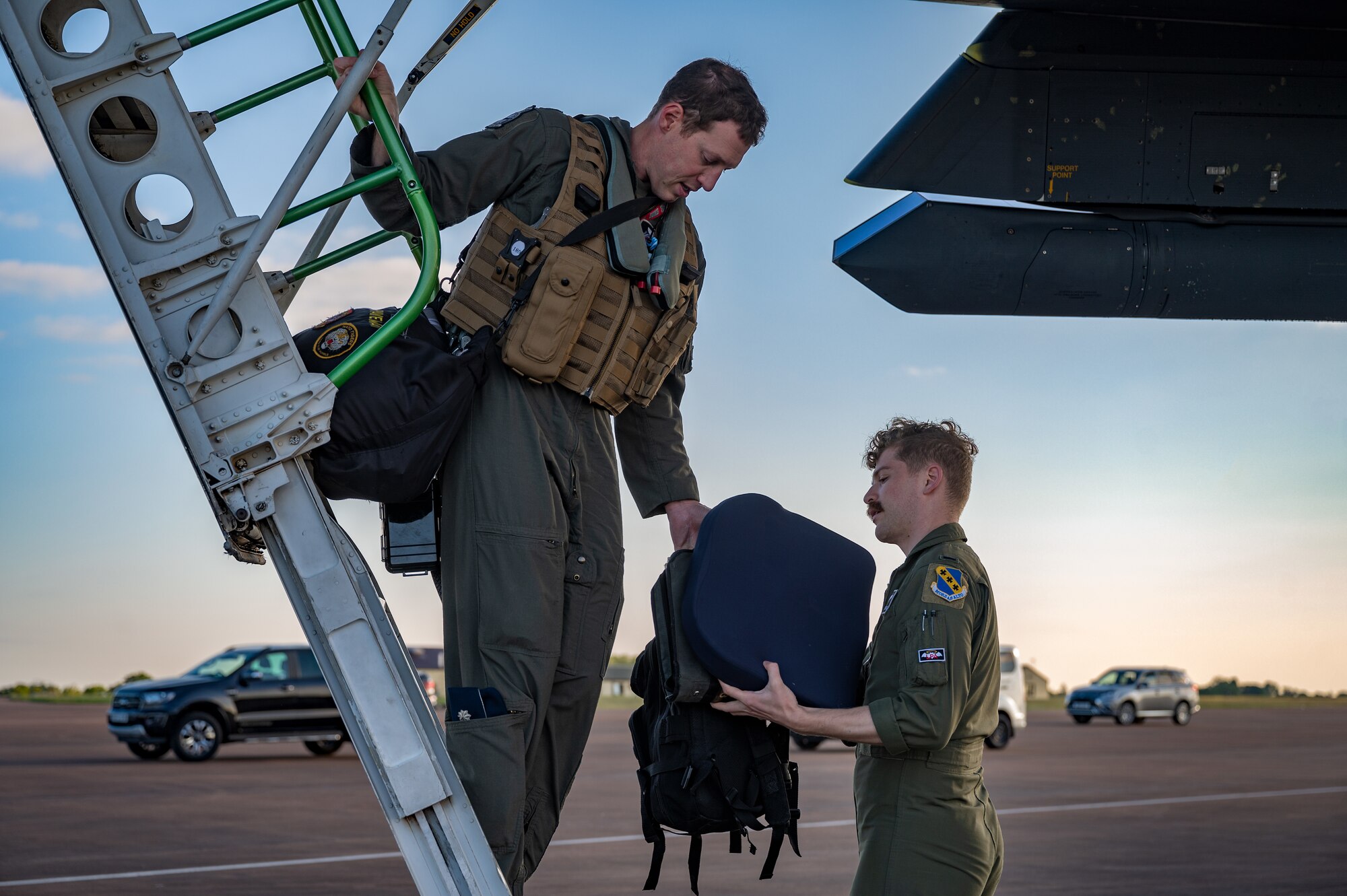 Lt. Col. Matthew Barnard, 9th Expeditionary Bomb Squadron director of operations, left, hands 1st Lt. Miles D’ascensio, B-1B Lancer pilot assigned to the 9th EBS, cargo off the B-1B Lancer at RAF Fairford, United Kingdom, Jun. 1, 2023.