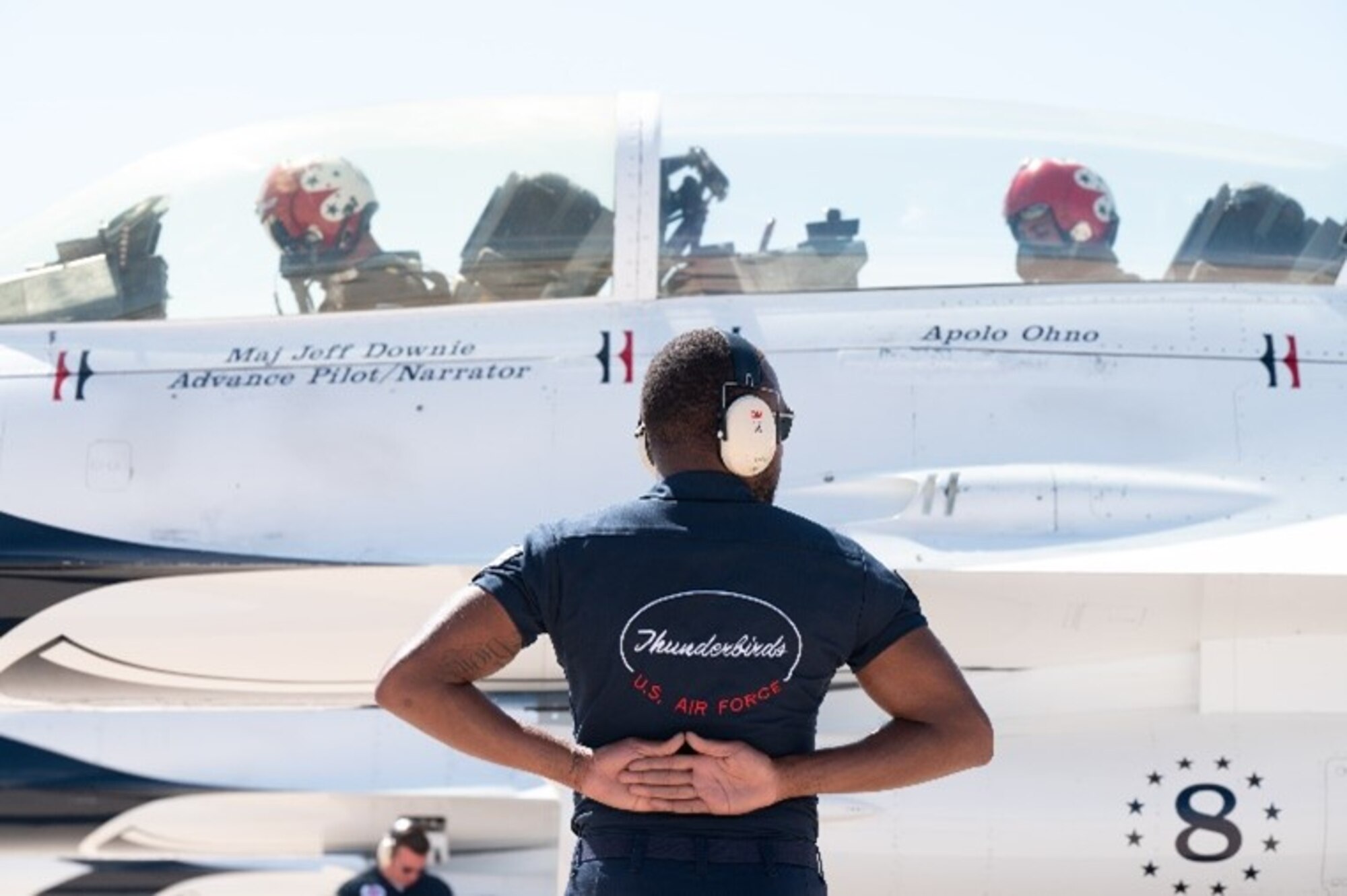 A member of the U.S. Air Force Demonstration Squadron “Thunderbirds” prepares to clear U.S. Air Force Thunderbirds #8 Advance Pilot Maj. Jeffrey "Simmer" Downie and eight-time Olympic medalist Apolo Ohno for takeoff on Peterson Space Force Base, Colorado, May 31, 2023.
