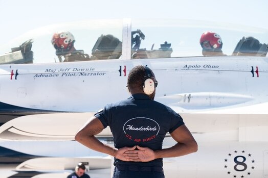  A member of the U.S. Air Force Demonstration Squadron “Thunderbirds” prepares to clear U.S. Air Force Thunderbirds #8 Advance Pilot Maj. Jeffrey "Simmer" Downie and eight-time Olympic medalist Apolo Ohno for takeoff on Peterson Space Force Base, Colorado, May 31, 2023.