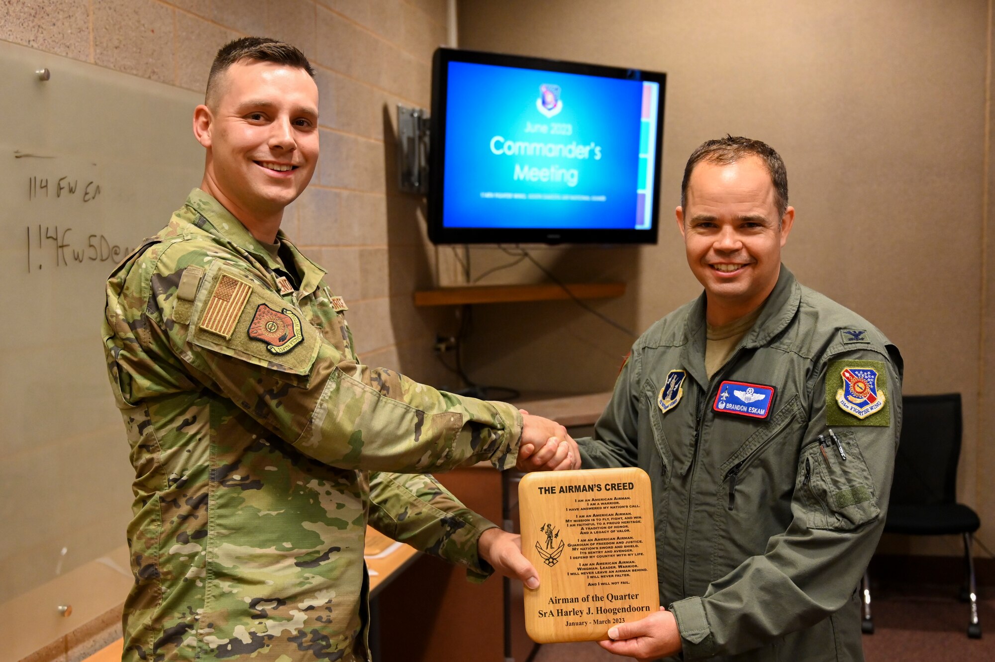 U.S. Air National Guard Col. Brandon Eskam, commander, 114th Fighter Wing, presents Senior Airman Harley Hoogendoorn, aviation resource management, 175 Fighter Squadron, with a plaque for Airman of the Quarter at Joe Foss Field, S.D., June 3, 2023.
