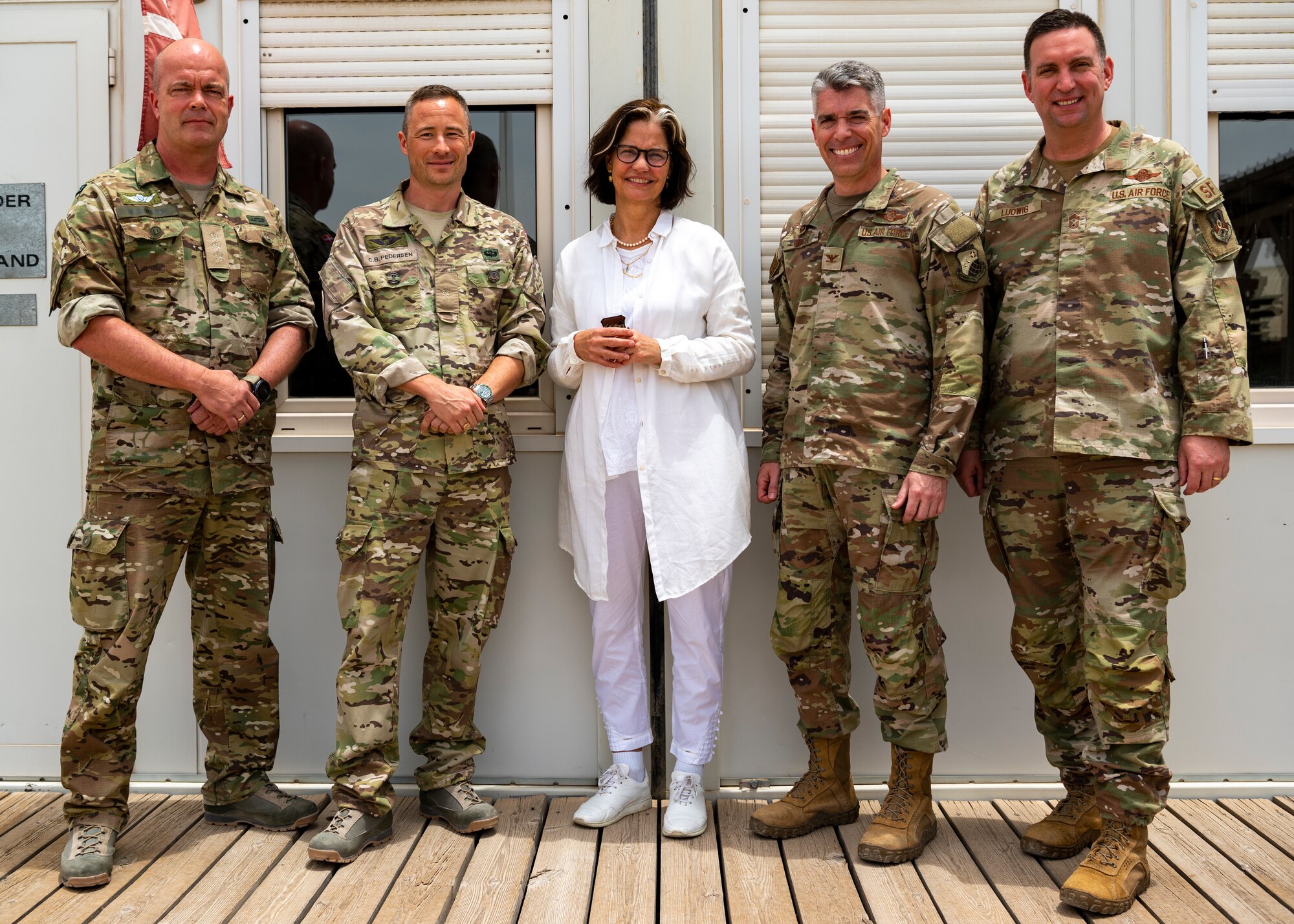 U.S. Air Force Col. George Buch, 386th Air Expeditionary Wing commander, and Chief Master Sgt. Louis Ludwig, 386th AEW command chief, pose for a photo with Liselotte Plesner, Ambassador of Denmark and other Danish coalition partners at Ali Ali Al Salem Air Base, Kuwait, May 31, 2023.