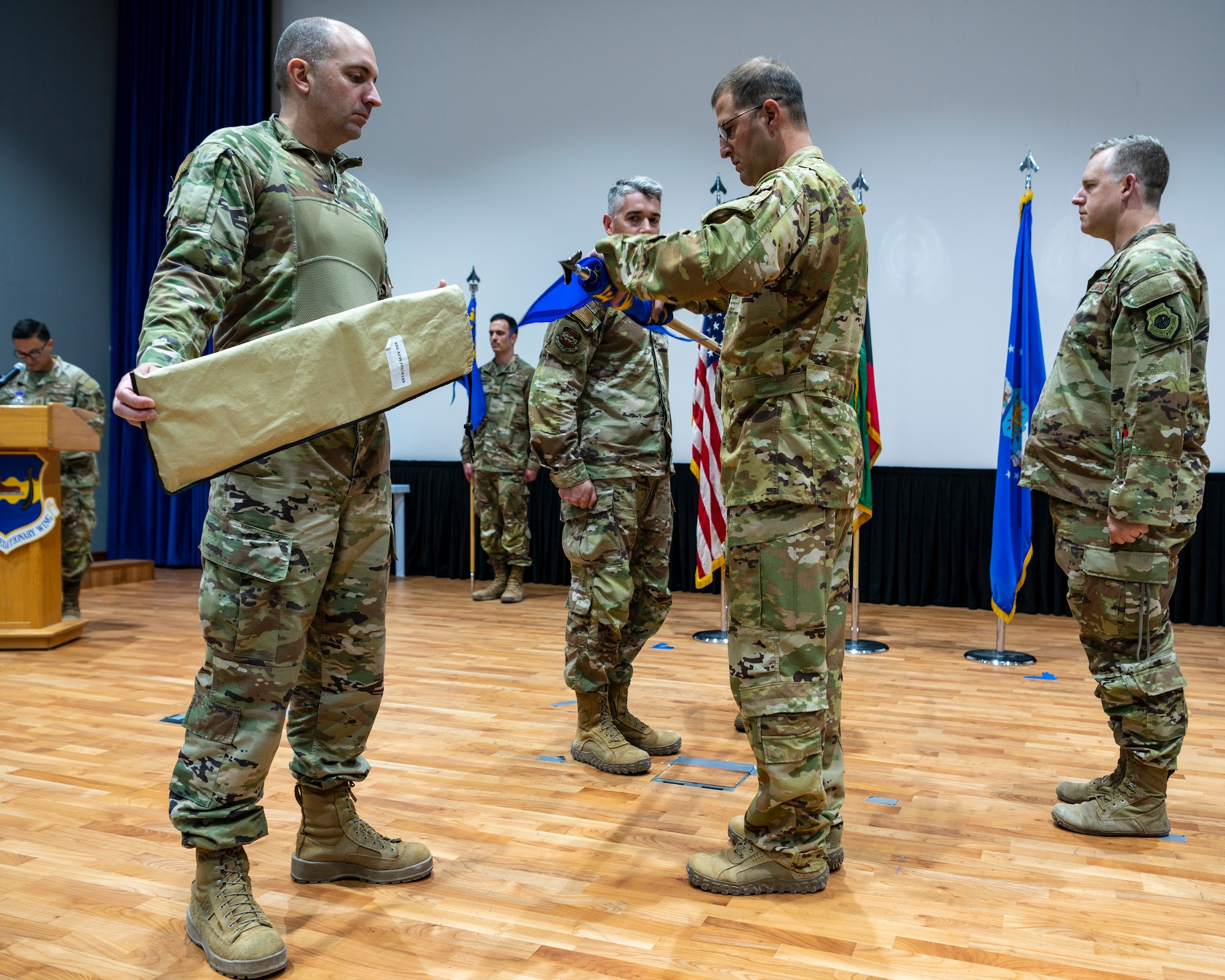 U.S. Air Force Airmen furl and sheathe the 407th EOSS guidon, as the squadron was re-designated to the 386th EOSS, June 2, 2023, at Ali Al Salem Air Base, Kuwait.