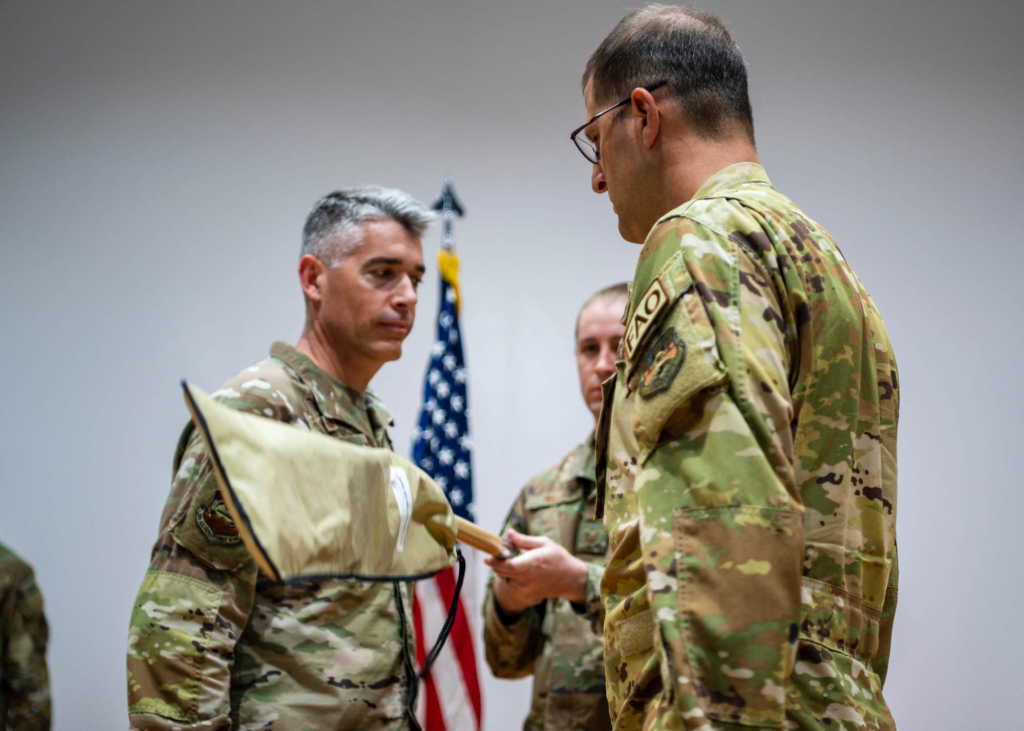 U.S. Air force Airmen furl and sheathe the 407th EOSS guidon, during the squadron re-designation to the 386th EOSS, June 2, 2023, at Ali Al Salem Air Base, Kuwait.