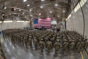 a crowd of airmen stand in orderly formation for a change of command