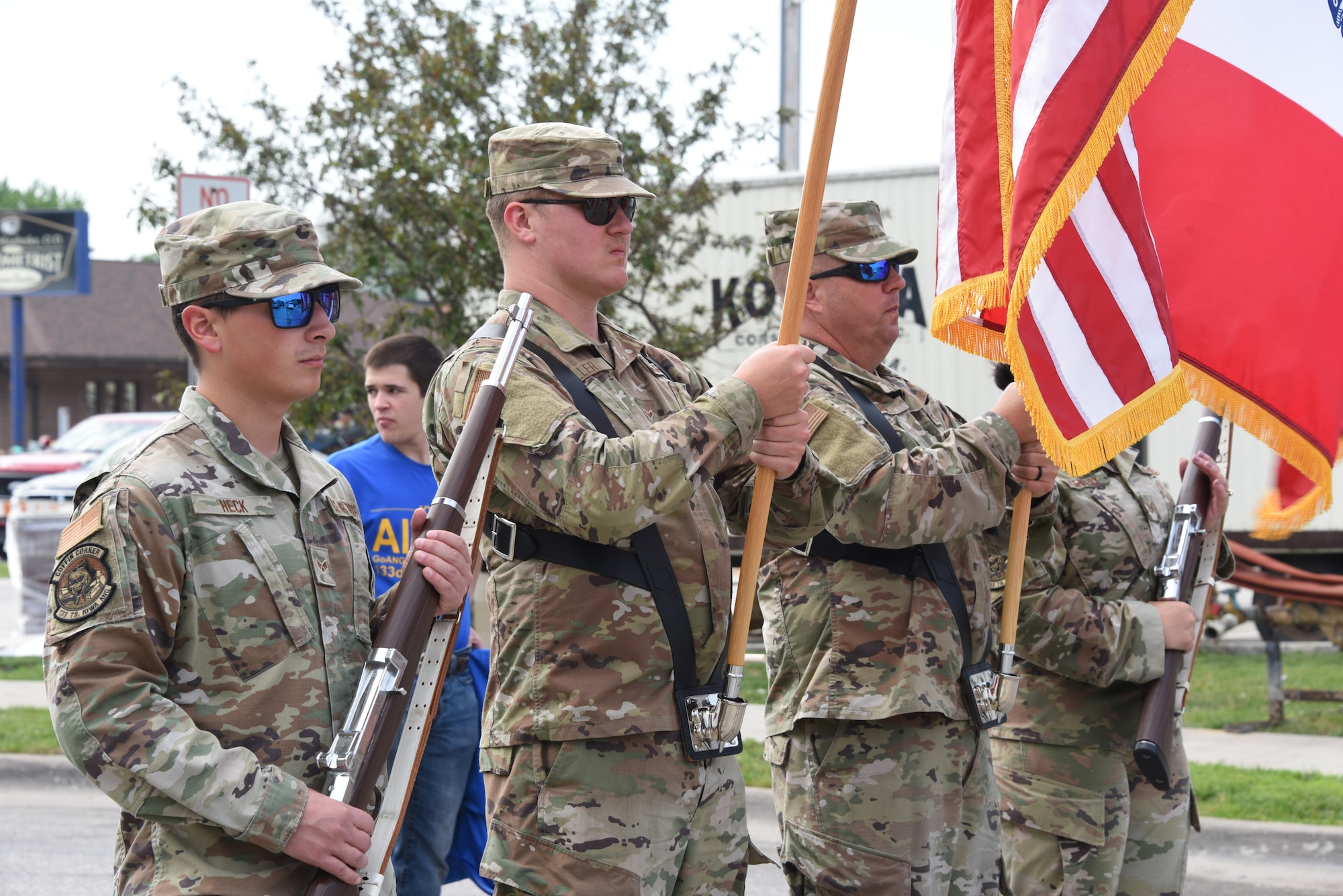 Airmen hold flags and ceremonial rifles.
