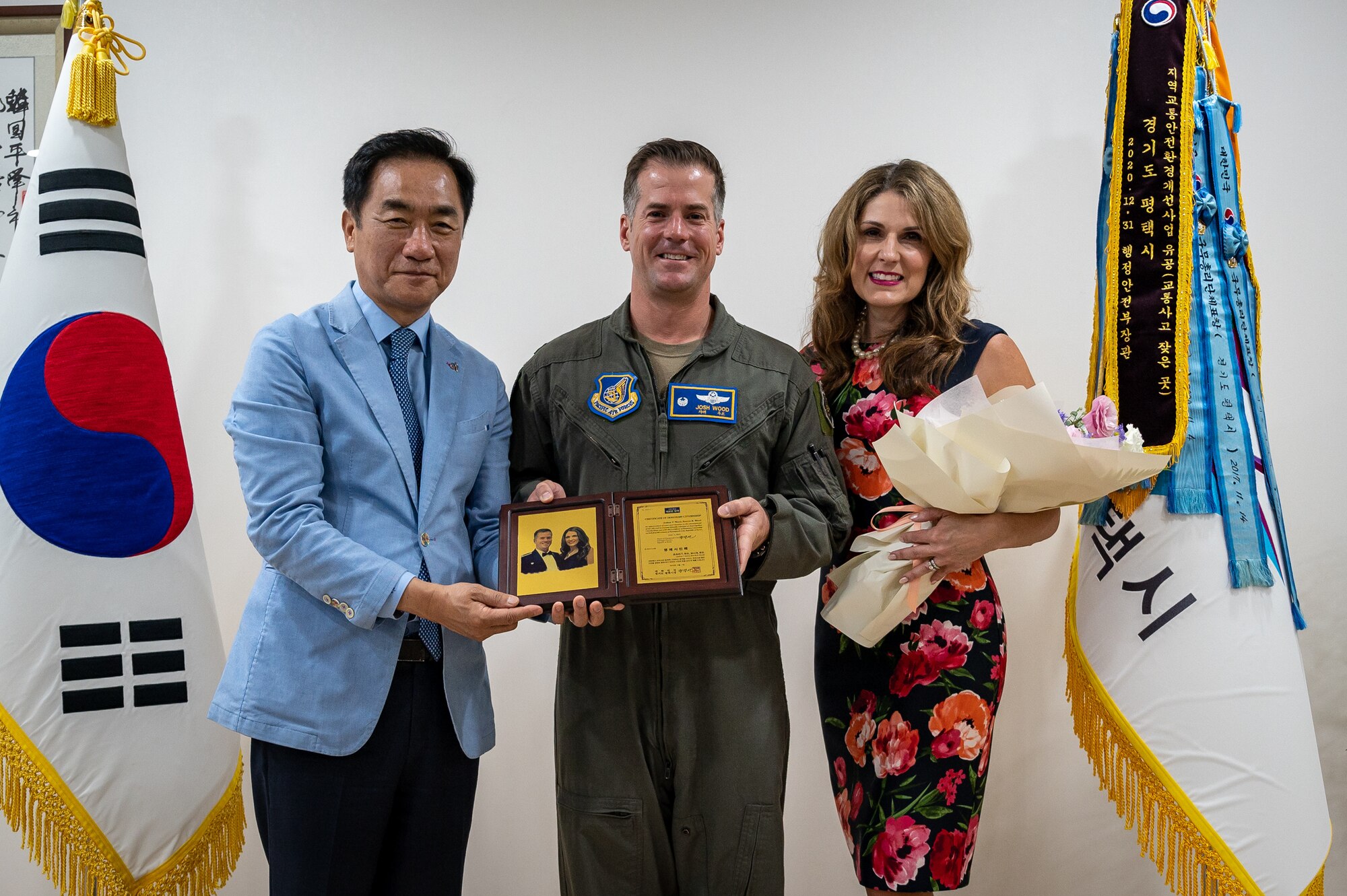 Mr. Jung, Jang Seon, left, Pyeongtaek City mayor, presents U.S. Air Force Col. Joshua Wood, middle, 51st Fighter Wing Commander, and his wife, Mrs. Bonnie Wood, with a plaque of honorary citizenship at Pyeongtaek City Hall, Republic of Korea, June 1, 2023. Wood has served as the 51 FW Commander for two years and is due to retire in July of 2023. (U.S. Air Force photo by Senior Airman Thomas Sjoberg)