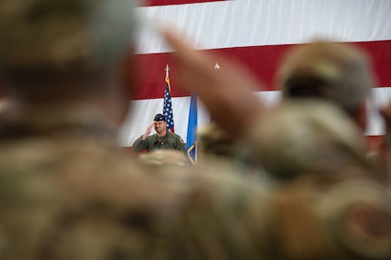 a man in uniform salutes a crowd