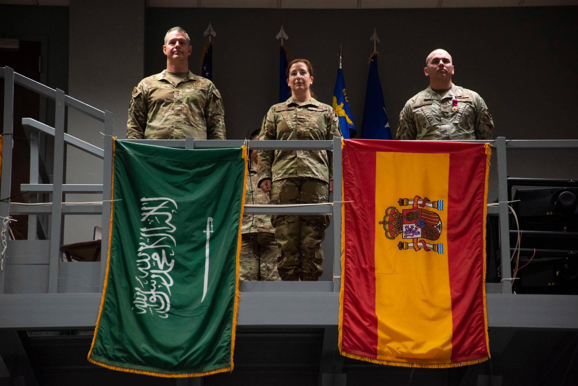 U.S. Air Force Lt. Gen. Alexus Grynkewich, Ninth Air Force (Air Forces Central) commander, and Combined Forces Air Component Commander for U.S. Central Command, left, Col. Julie Sposito-Salceies, center, and Col. Kevin Ogle, stand at attention during the 609th Air Operations Center change of command ceremony.