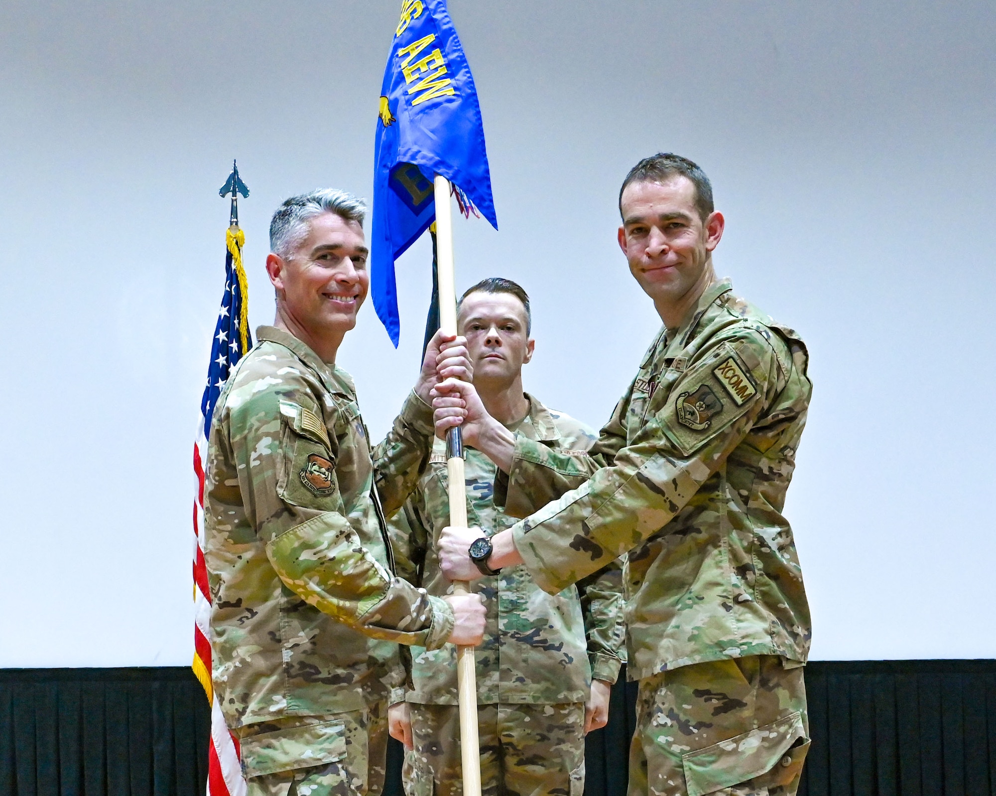 Col. George Buch, 386th Air Expeditionary Wing commander, passes the guidon to Maj. Christopher Arnold, incoming 386th Expeditionary Communications Squadron commander, during a change of command ceremony at Ali Al Salem Air Base, Kuwait, June 5, 2023.