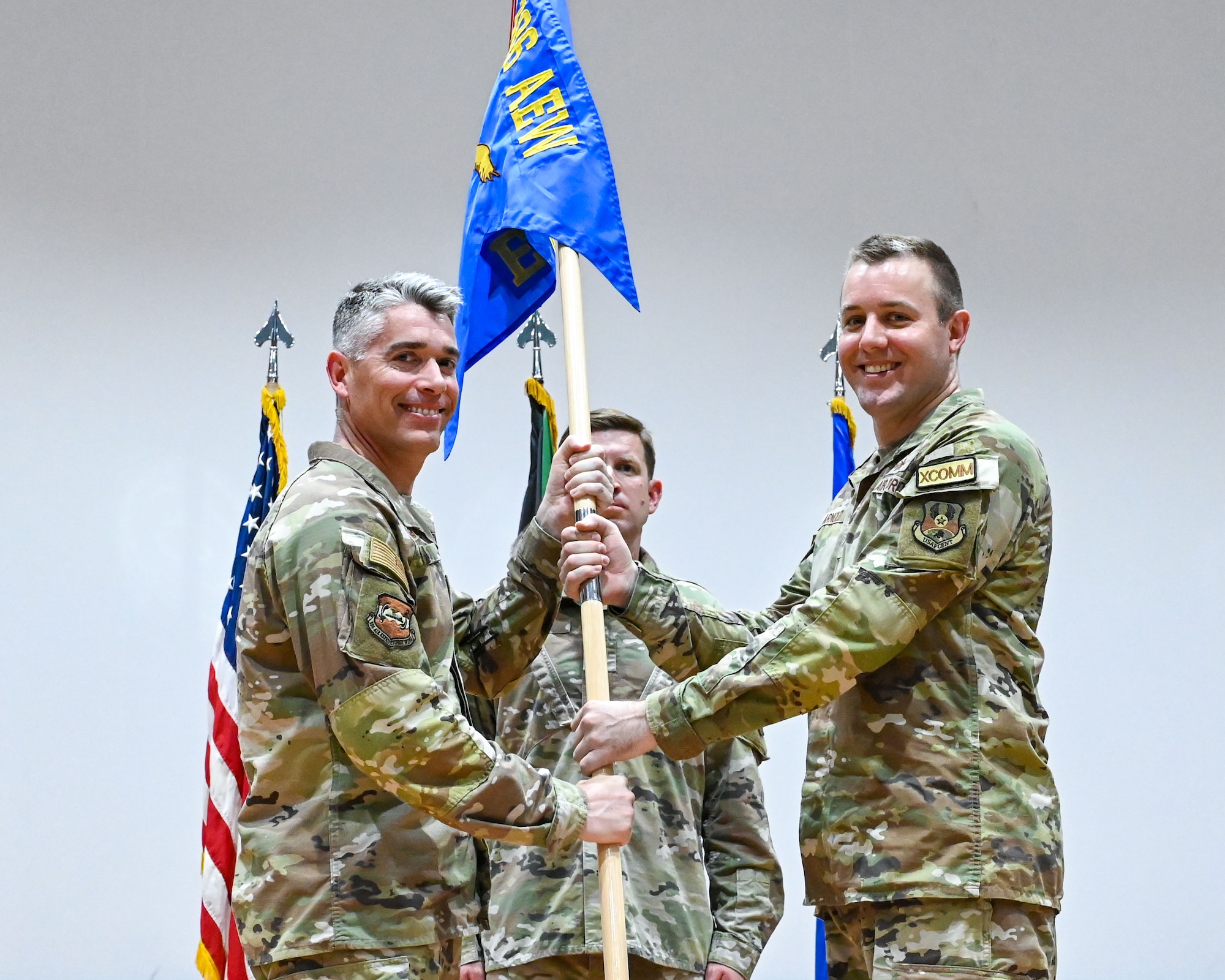 Col. George Buch, 386th Air Expeditionary Wing commander, passes the guidon to Maj. Christopher Arnold, incoming 386th Expeditionary Communications Squadron commander, during a change of command ceremony at Ali Al Salem Air Base, Kuwait, June 5, 2023.