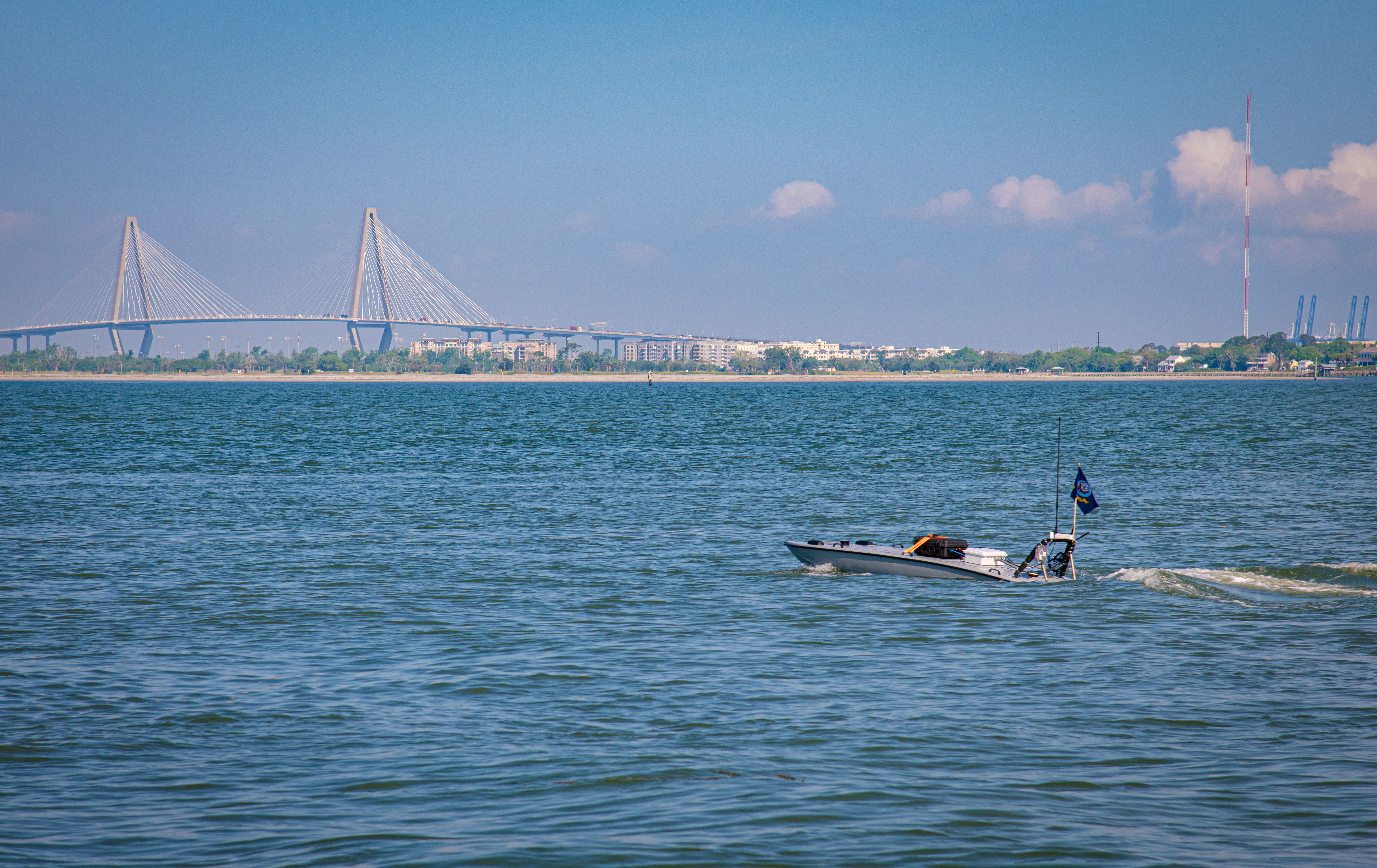 Unmanned surface vessel in water.  Behind in the distance is the Arthur Ravenel Bridge