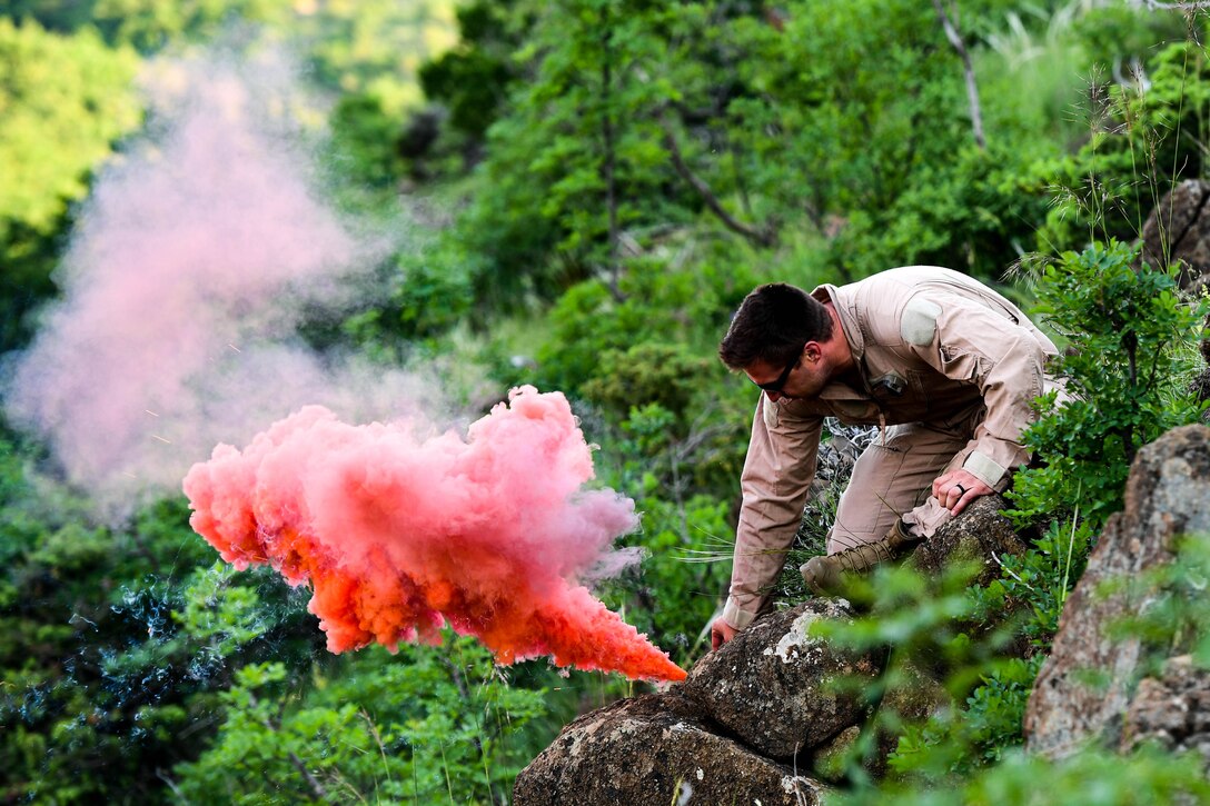 A soldier puts a signal flare on the ground.
