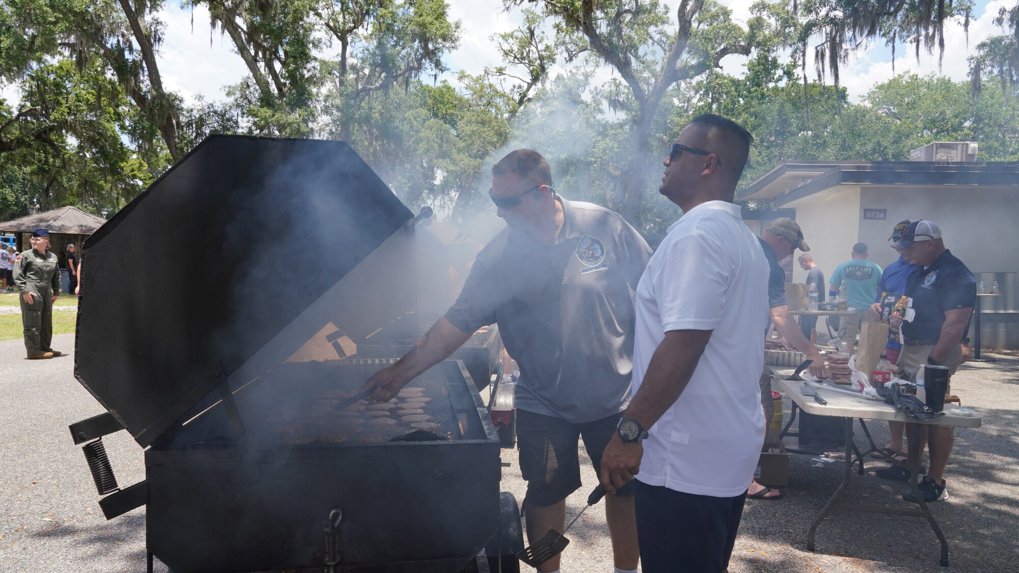 Chief Master Sgts. work the grills cooking during the family day celebration.
