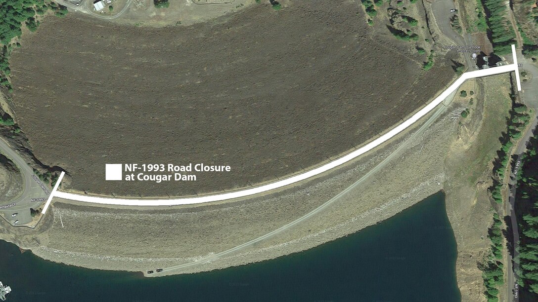 Aerial view above Cougar Dam showing the closure of NF-1993 across the dam crest.