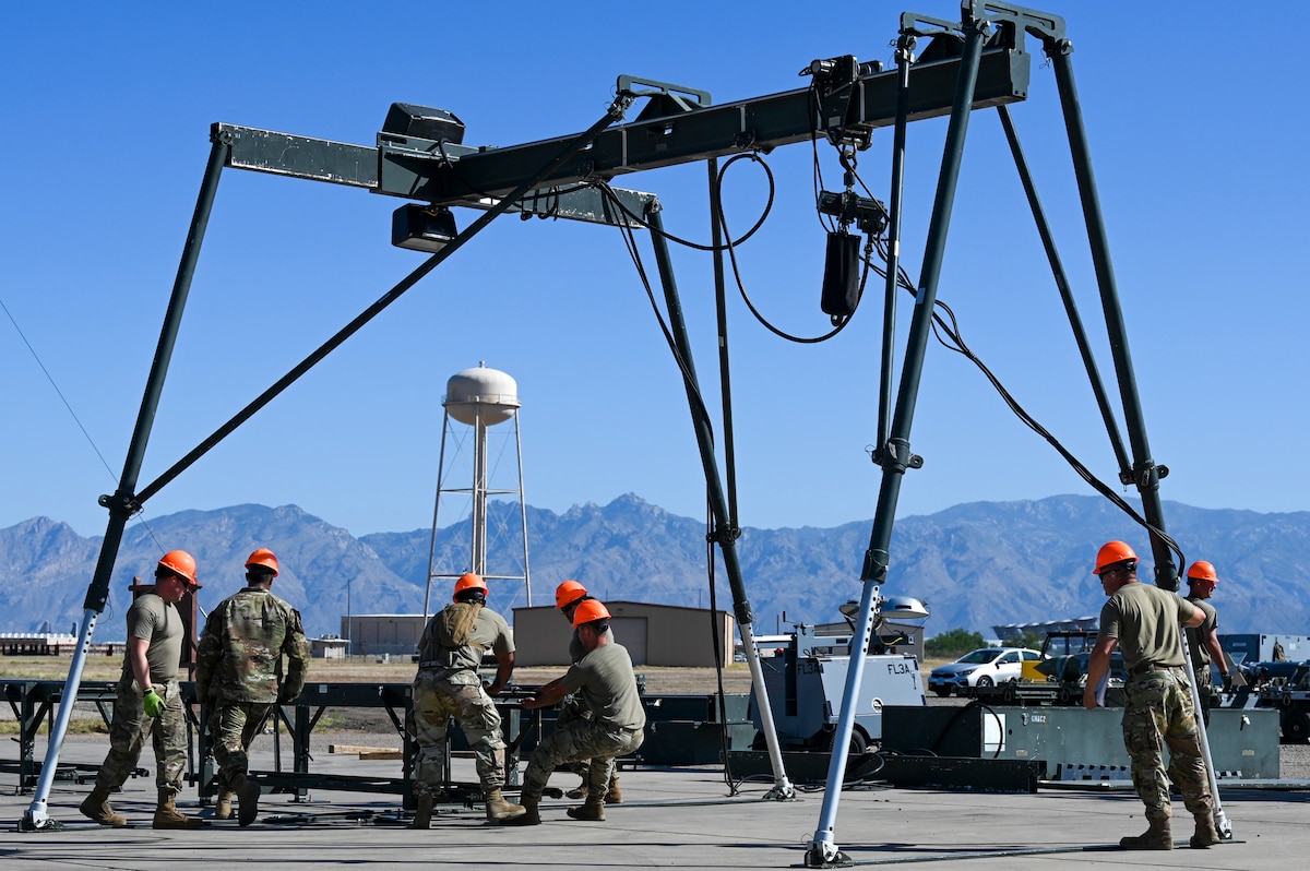 A photo of people in military uniforms building a munitions assembly conveyor.