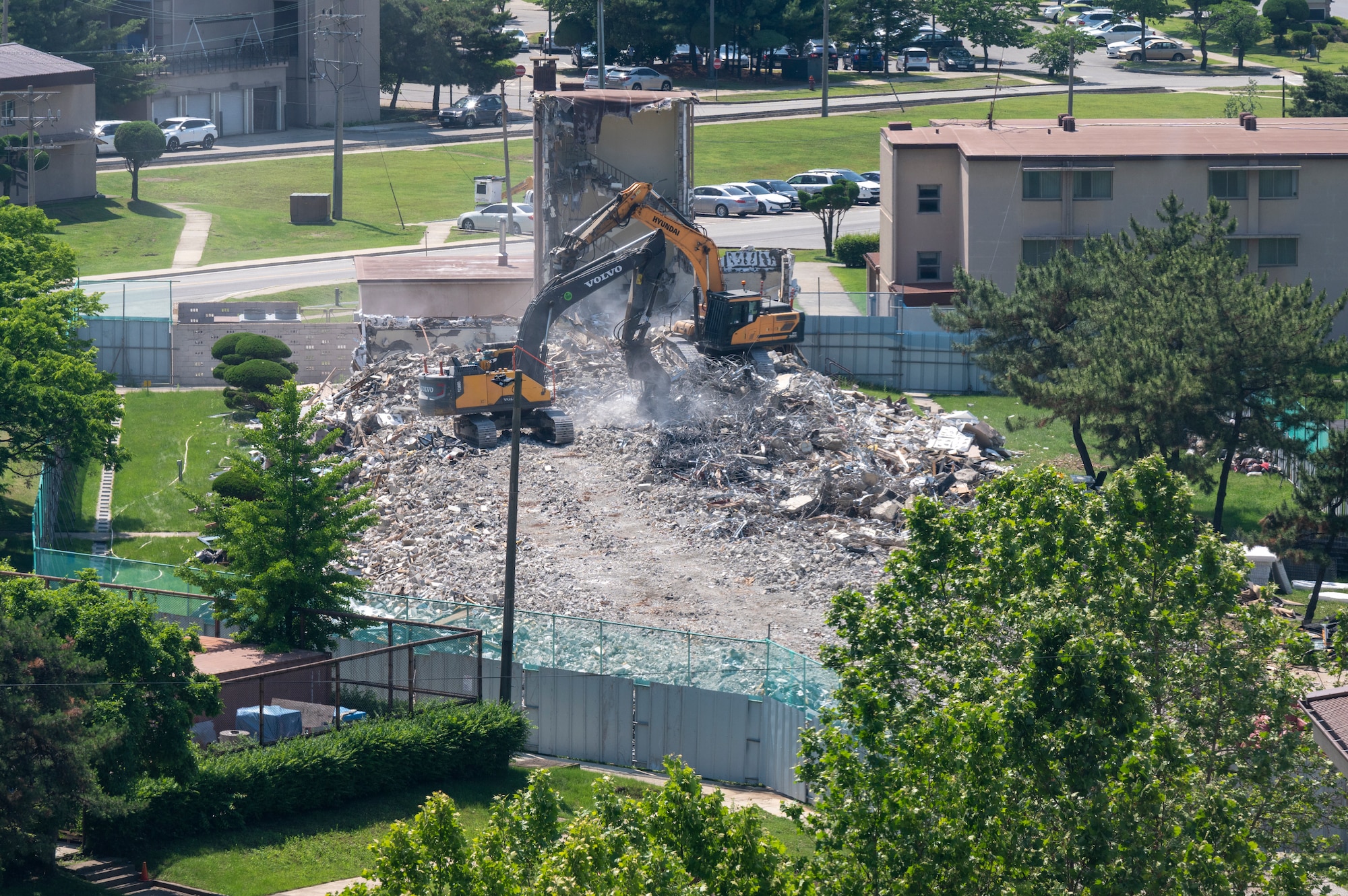 Construction workers demolish a condemned dorm at Osan Air Base, Republic of Korea, May 31, 2023.The demolition of building 708 is a part of base-wide improvements currently being implemented by the 51st Civil Engineer Squadron. (U.S. Air Force photo by Airman 1st Class Aaron Edwards.)