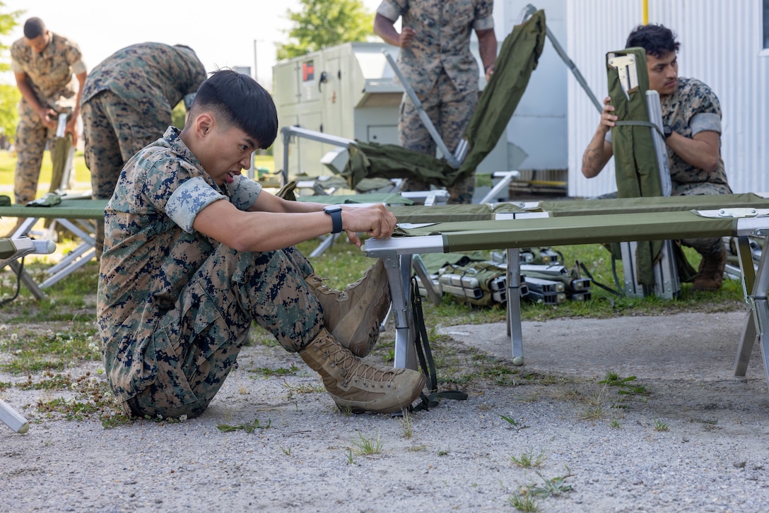 U.S. Marine Corps Cpl. Mace Blanchard, a range coach assigned to Headquarters and Headquarters Squadron sets up a cot for a temporary emergency shelter during an exercise at the Marine Dome, Marine Corps Air Station (MCAS) Cherry Point, North Carolina, May 15, 2023. MCAS Cherry Point tested multiple scenarios during HURREX 2023, a week-long preparation exercise to test the air station’s ability and response time of various aspects to endure a destructive storm. (U.S. Marine Corps photo by Lance Cpl. Lauralle Walker)