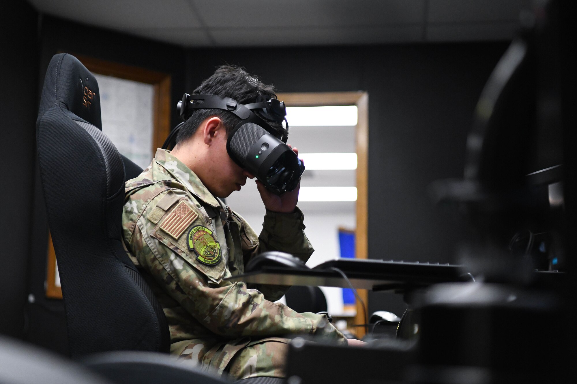 Man in military uniform adjusts virtual reality headset