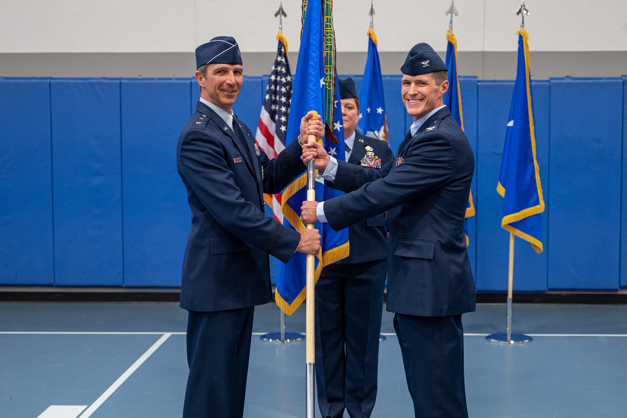 two individuals holding a flag, and posing for a photo.