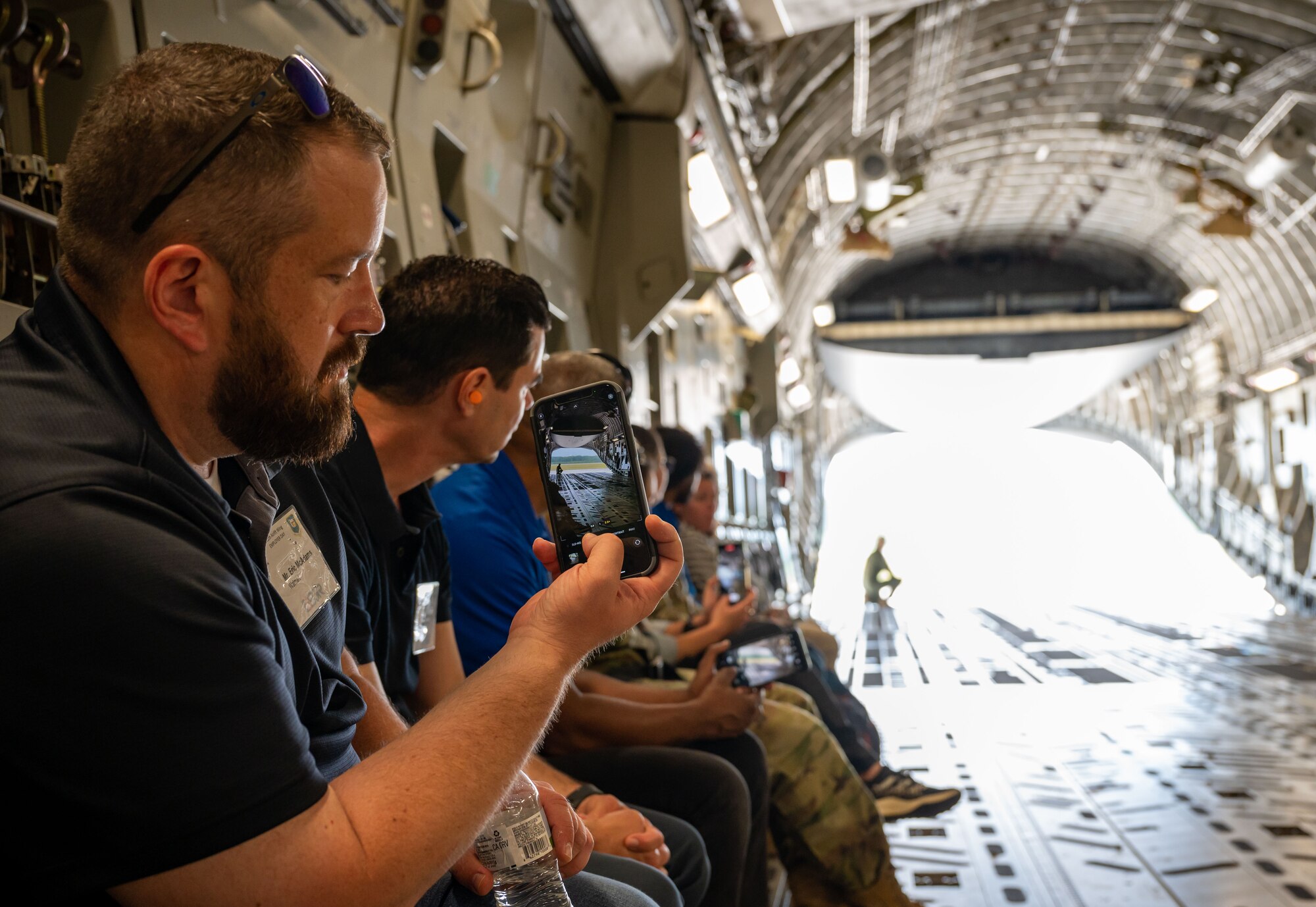 Eric McAdams, Employer Support of the Guard and Reserve member, takes a picture on his cell phone before an incentive flight at Dover Air Force Base, Delaware, June 3, 2023. ESGR, a Department of Defense office, was established in 1972 to promote cooperation and understanding between Reserve Component Service members and their civilian employers and to assist in resolving conflicts arising from an employee's military commitment. (U.S. Air Force photo by Airman 1st Class Amanda Jett)