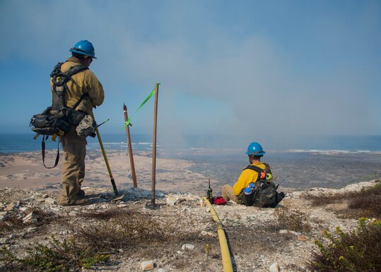 Mike Rivera and Alex Duncan, Vandenberg Wildland Support Module fire operation technicians, observe the controlled fire Sept. 18, 2019 at Vandenberg Air Force Base, Calif. The Vandenberg Fire Department and Hotshots team conducted a prescribed burn of grassland and coastal sage scrub. (U.S. Air Force photo by Airman 1st Class Aubree Milks)