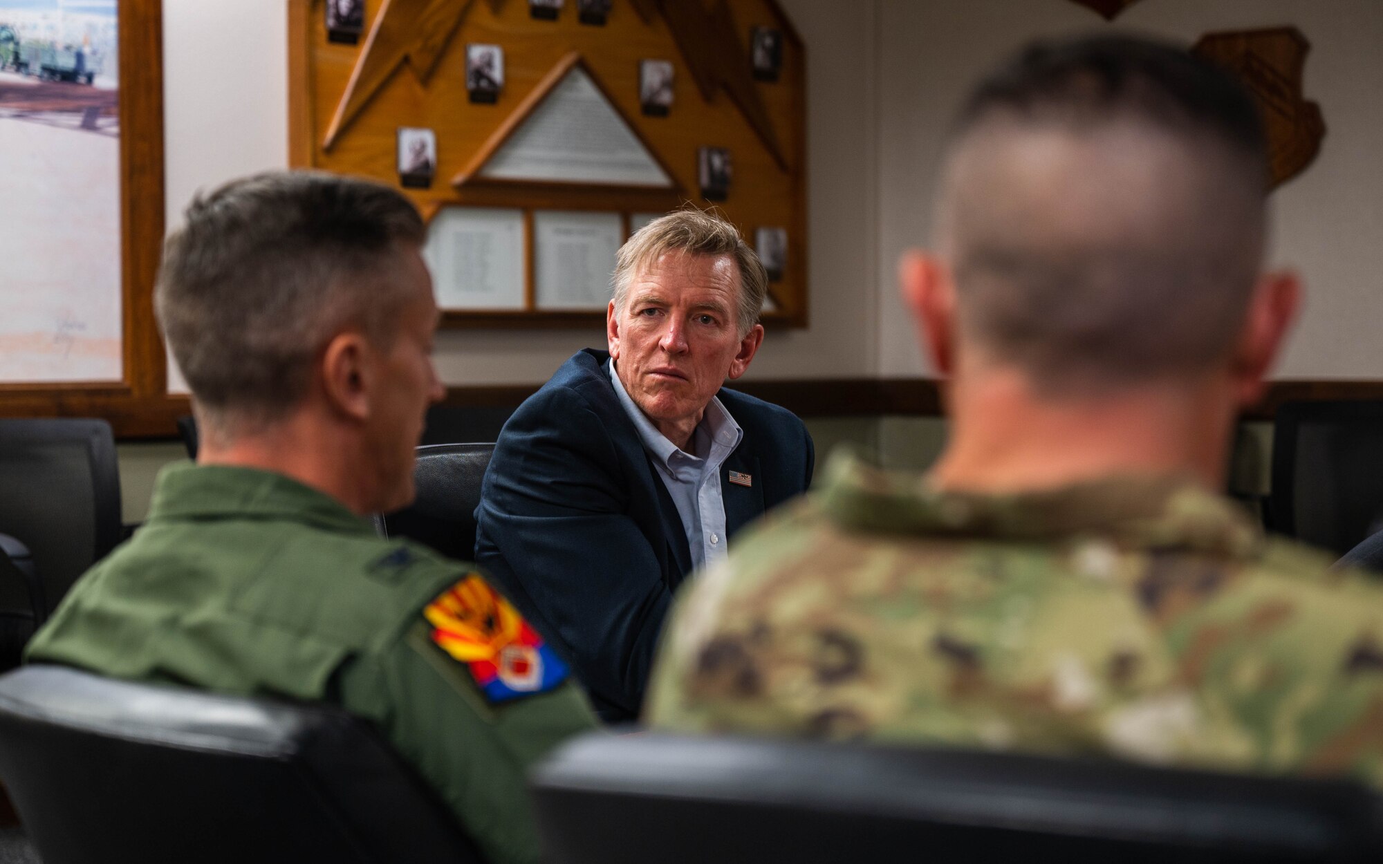 U.S. Representative Paul Gosar looks at U.S. Air Force Col. Keagan McLeese as he speaks to him in a conference room at Luke AFB headquarters
