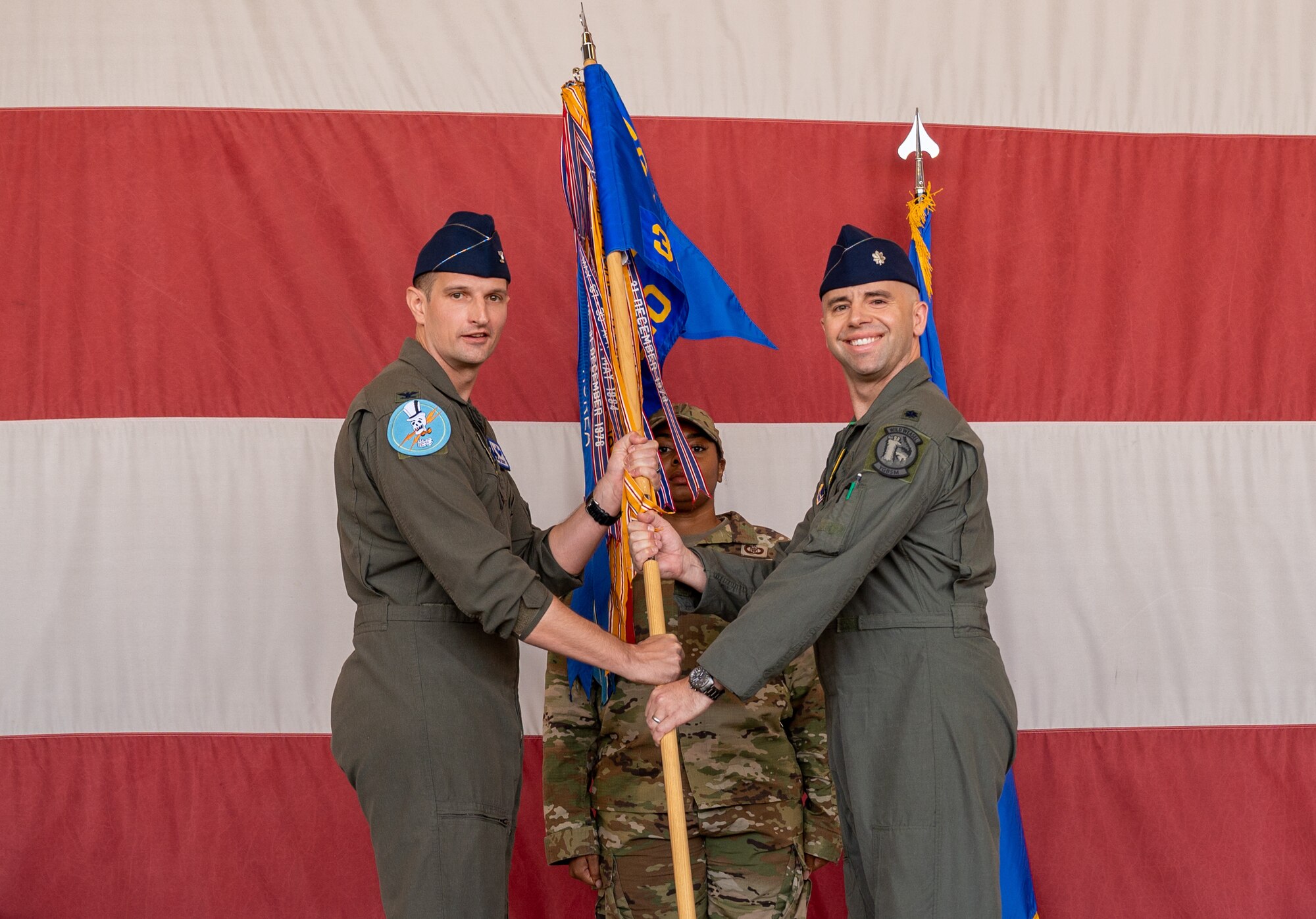 U.S. Air Force Col. Matthew Johnston (left), 56th Operations Group commander, hands the guidon to U.S. Air Force Lt. Col. Adam Vogel (right), 310th Fighter Squadron commander, at an assumption of command ceremony June 2, 2023, at Luke Air Force Base, Arizona.