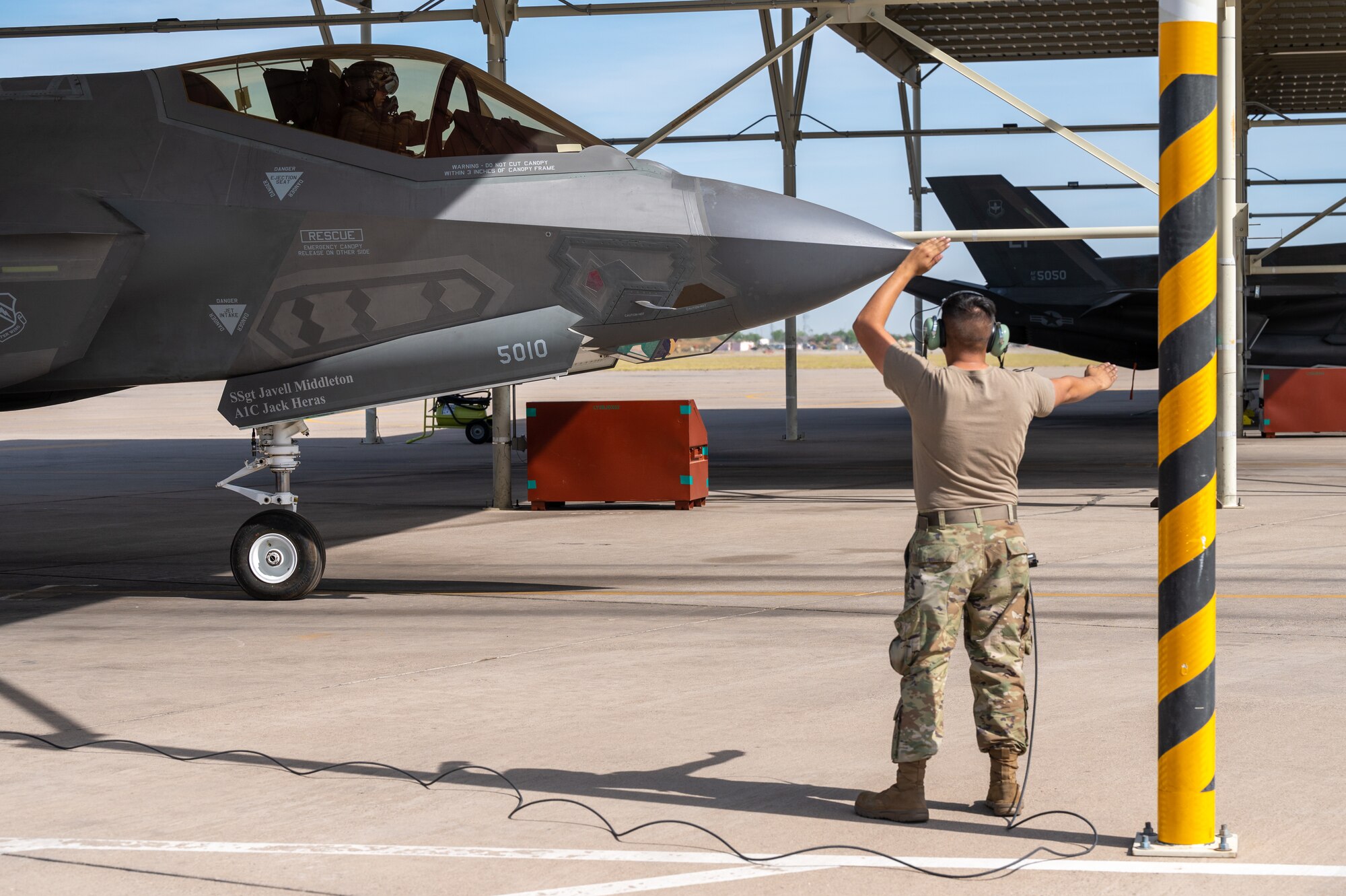 U.S. Air Force Senior Airman Zachary Calderon (right), 308th Aircraft Maintenance Unit crew chief, signals to U.S. Air Force Lt. Col. Adam Vogel (left), 310th Fighter Squadron commander, June 5, 2023, at Luke Air Force Base, Arizona.