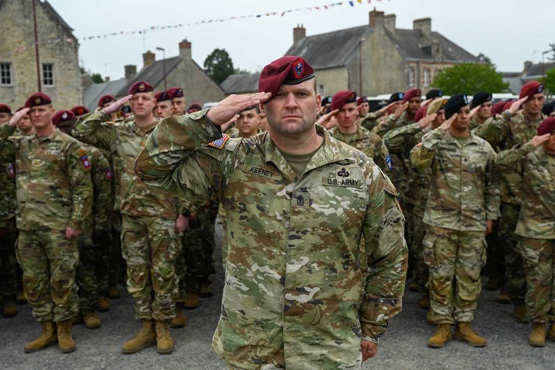 Soldiers salute while standing at attention.