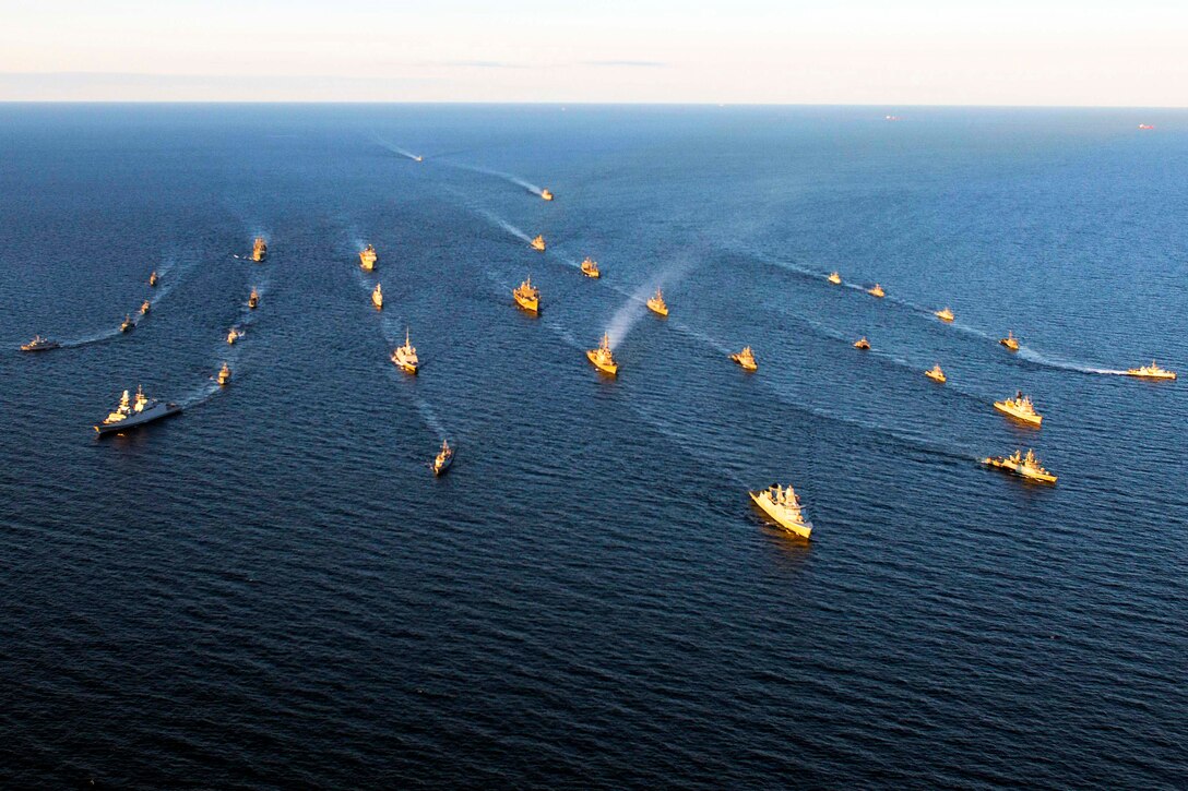 Ships sail in formation in the Baltic Sea.