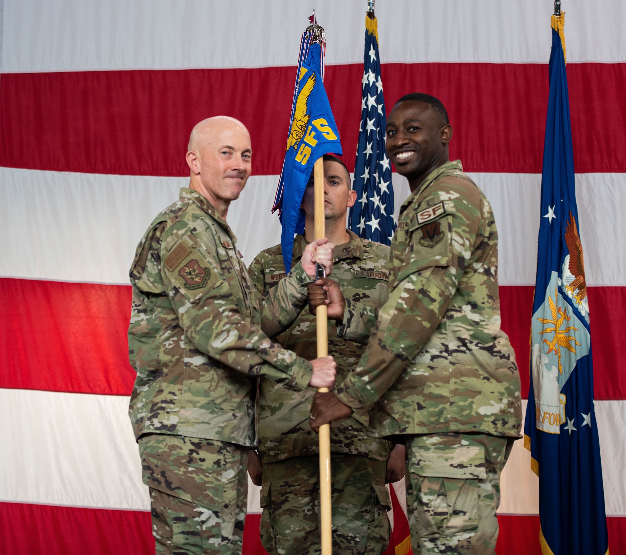 An Air Force colonel passes a guidon over to a new commander