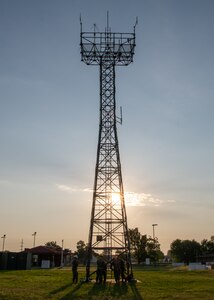 A group of Airmen with the 219th Engineering Installation Squadron prepare for training at the base of an antenna tower in preparation for their training at Tulsa Air National Guard Base, Okla., June 3, 2023. Tower rescue is an annual requirement that the Airmen must pass in order to be mission ready, whether that be at home or at a another country. (U.S. Air National Guard Photo by Airman 1st Class Addison Barnes )