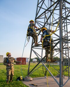Airman 1st Class Joseph Coppinger, 219th Engineering Installation Squadron cable and antenna systems technician, assists in the ascent of Airman 1st Class Gregory Crowder and Joe Kuhn, 219th Engineering Installation Squadron cable and antenna systems technicians, as they scale the antenna tower for tower rescue training at Tulsa Air National Guard Base, Okla., June 3, 2023. While the certification is renewed annually, Airmen at the 219th EIS often do it multiple times a year in order to be mission ready and to instill confidence in their abilities. (U.S. Air National Guard Photo by Airman 1st Class Addison Barnes)