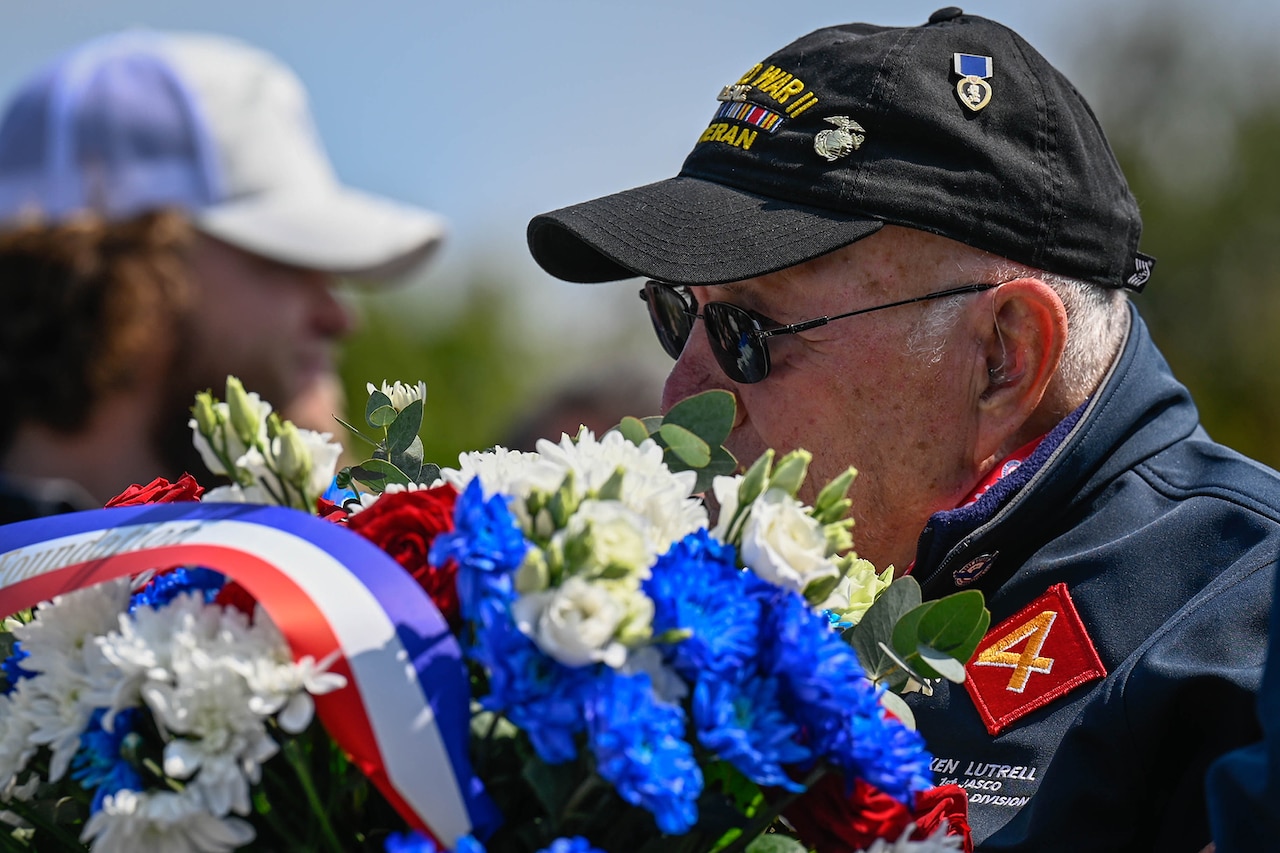 A veteran smells flowers during a D-Day memorial.