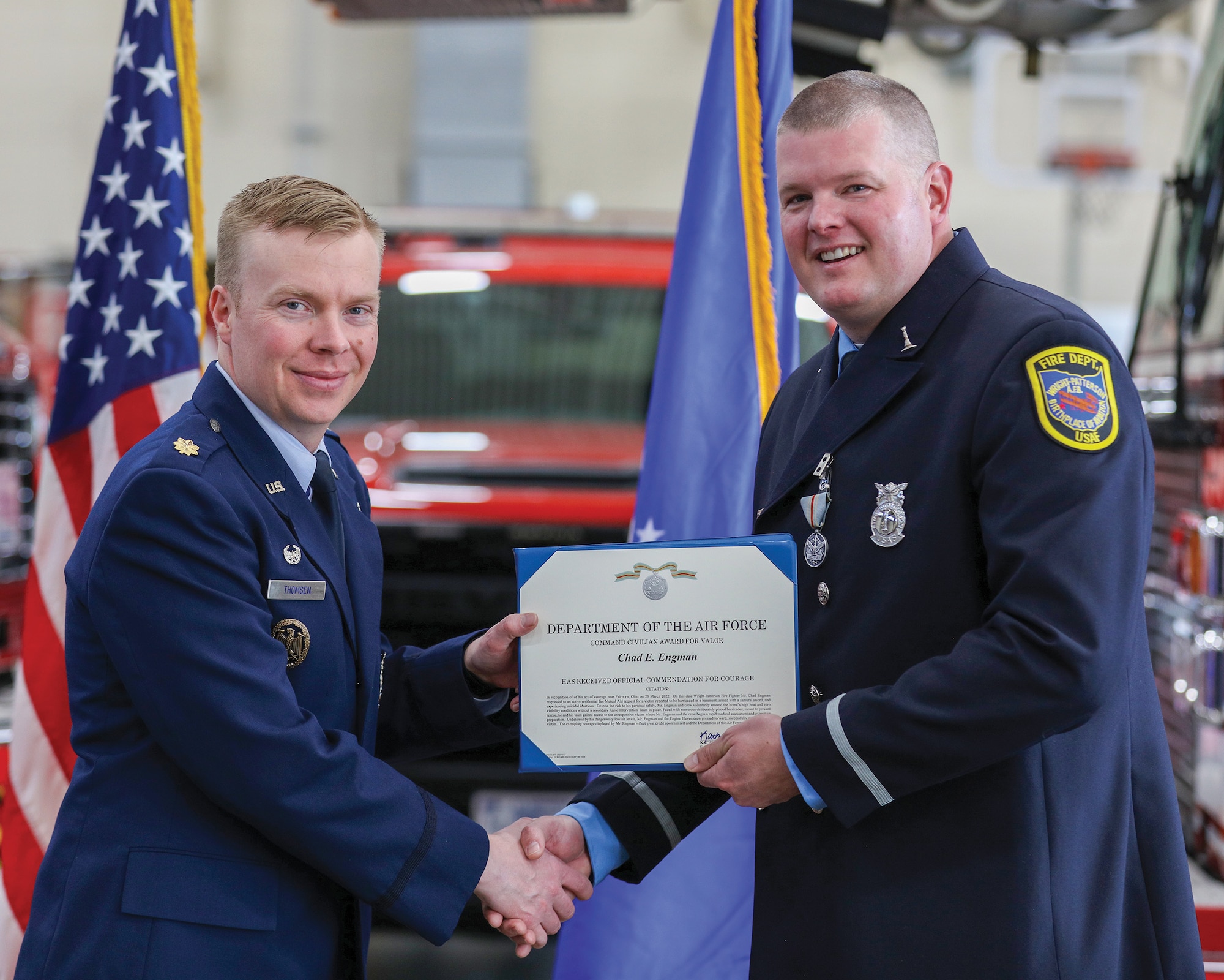 Maj. Nathan Thomsen, 788th Civil Engineer Squadron commander, presents Lt. Chad Engman, 788th and 445th CES firefighter with a Command Civilian Award for Valor certificate at Wright-Patterson Air Force Base, Ohio, May 10, 2023.