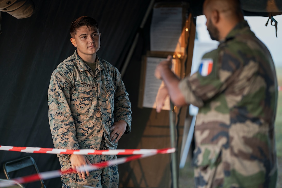 U.S. Marine Lance Cpl. William Carpenter, a motor vehicle operator with Combat Logistics Battalion 5, Combat Logistics Regiment 1, 1st Marine Logistics Group, greets French Navy personnel at the Evacuation Collection Center in Koumac, New Caledonia during Exercise Croix du Sud, May 4, 2023. Croix du Sud is the New Caledonian Armed Forces’ Combined Joint Task Force certification event with training objectives focused on a Humanitarian Assistance and Disaster Response, Non-combatant Evacuation Operations, and Stability and Support Operations scenario in Oceania with desired effects focused on enhancing military-military, civil-military, and joint/multinational coordination in the region during crisis response. U.S. Marines with Combat Logistics Battalion 5, 1st Marine Logistics Group supported the ECC with a non-combatant evacuation operations team during the exercise, while also enhancing the Marine Corps’ ability to provide logistical support to the joint force and U.S. Allies and partners in future austere operations. (U.S. Marine Corps photo by Staff Sgt. Dana Beesley)