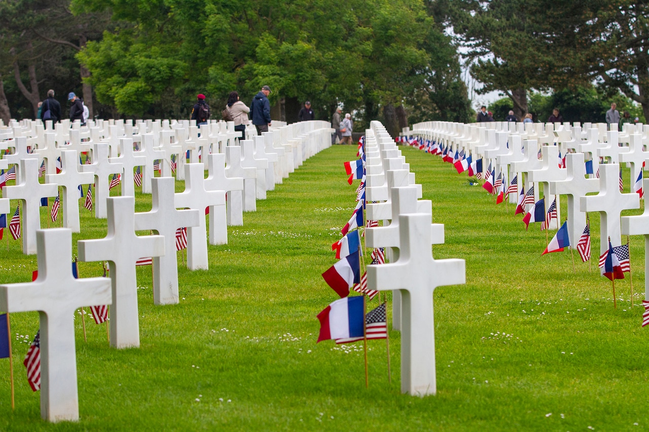 A row of graves featuring U.S. and French flags is photographed in the Normandy American Cemetery in France.