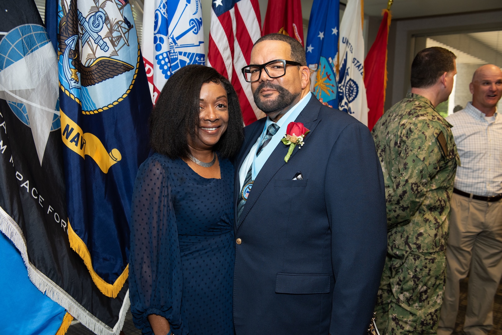 A dark skinned man and woman smile for the camera.