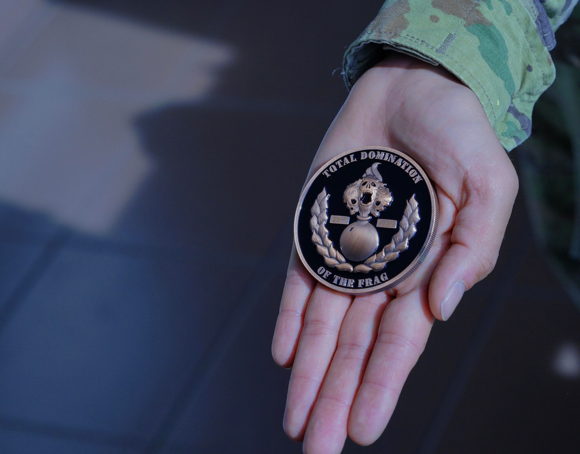 U.S. Air Force munitions Airman holds a 9th Munitions Squadron Fragmentation Order coin April 21, 2023, at Beale Air Force Base, California.